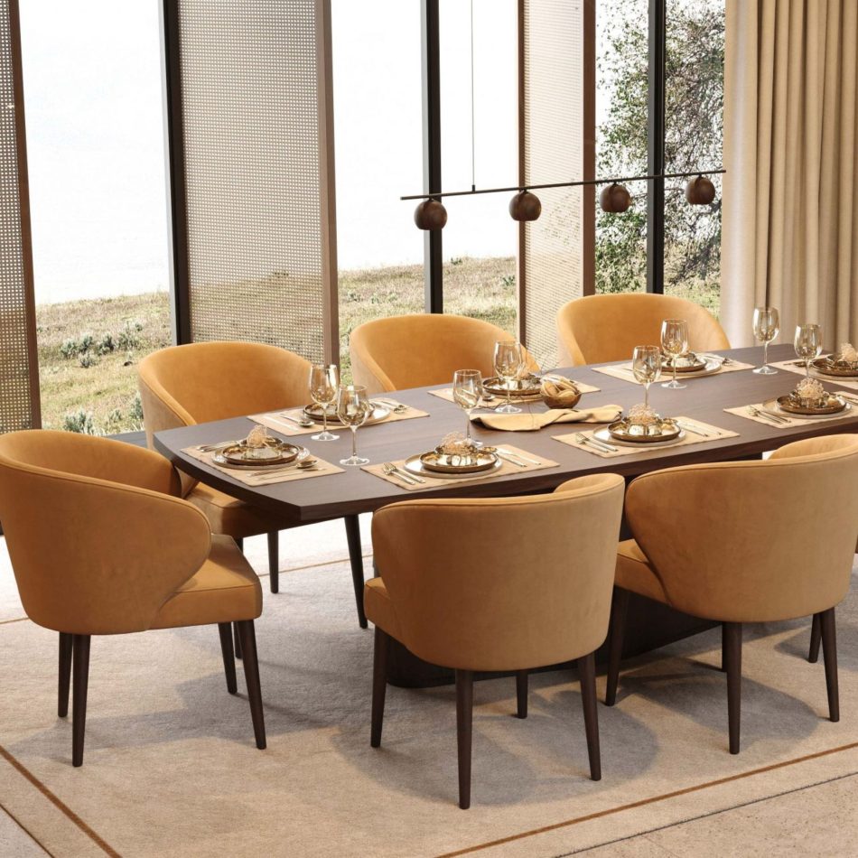 The Fortune Chairs surround a dark wooden dining table, their deep backs and curved arms creating a sense of comfort and quiet elegance. Upholstered in warm yellow tones, they elevate the room with a soft, welcoming presence, while the dark oak legs add an organic touch. The table is set with gold‑toned details that enhance the cosy, refined atmosphere. The scene reflects crafted luxury furniture, warm interior design and elegant homedecor.