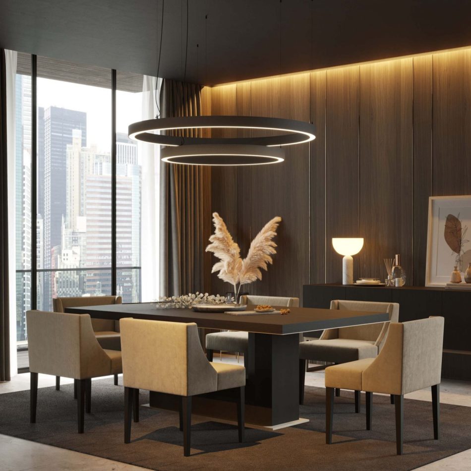 The Fortune Dining Table stands at the center of a elegant dining room, its dark top paired with soft beige upholstered chairs and sculptural ring‑shaped pendant lights above. Warm vertical wood panels and a softly lit sideboard frame the space, blending luxury dining room furniture, design details, and elegant dining room architecture.