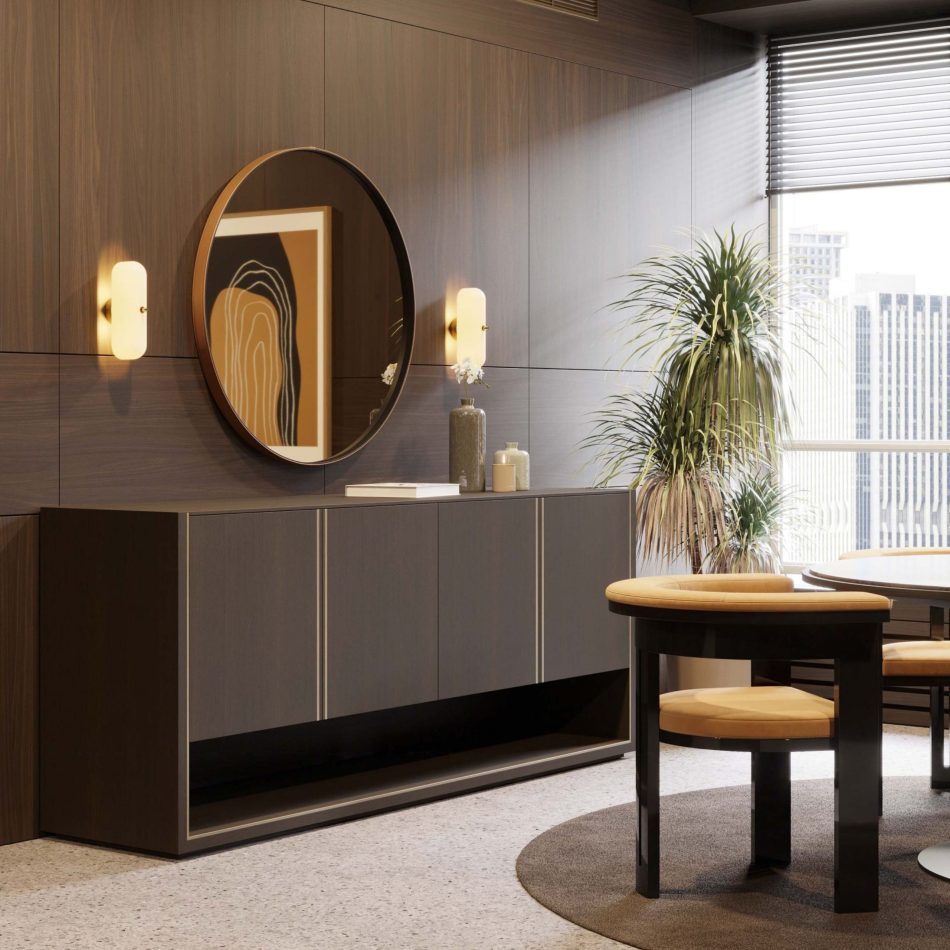 The Fortune Sideboard stands against a softly lit wall, featuring four matte dark‑brown oak doors outlined with brushed brass details that highlight its austere geometry. A large round mirror, warm wall lights, and decorative vases enhance the scene, blending luxury dining room furniture, expressive wood texture, and elegant design details.