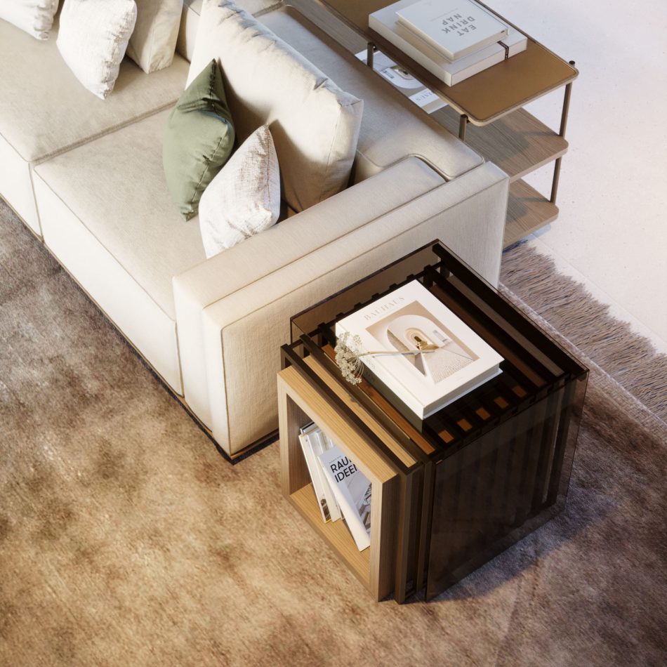 The His Side Table stands beside a beige sectional sofa, revealing its geometric three‑tiered structure crafted from wood and tinted glass in warm bronze tones. Styled with books and a coral‑inspired sculpture, the piece blends modern furniture, refined material contrast, and sophisticated living room inspiration.