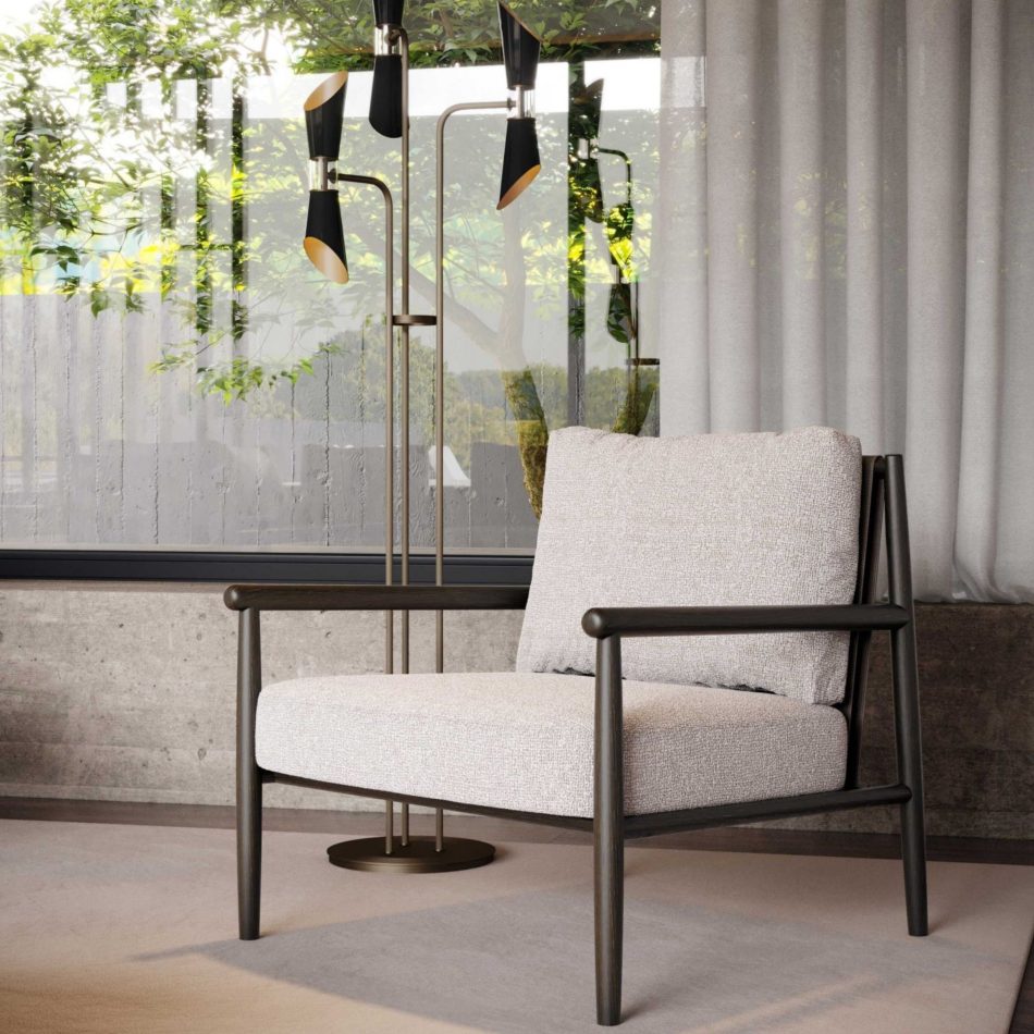 The Landform Armchair in a neutral bouclé beside a sculptural black and brass floor lamp, set against concrete detailing and sheer curtains with garden views, an example of luxury living room furniture with minimalist contrast.