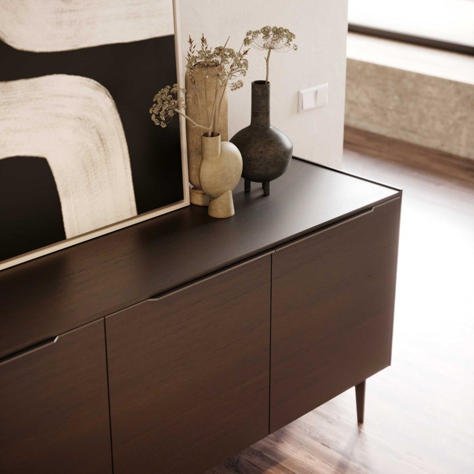 The Landform Sideboard anchors the space with its minimalist silhouette and rich wood texture, topped with earthy ceramic vases holding dried stems. A large abstract artwork with sweeping black and white curves creates a striking backdrop, enhancing the room’s calm, contemporary mood. The setting expresses the crafted identity of modern furniture, the quiet sophistication of luxury home furniture, and the sculptural presence associated with thoughtful design details.