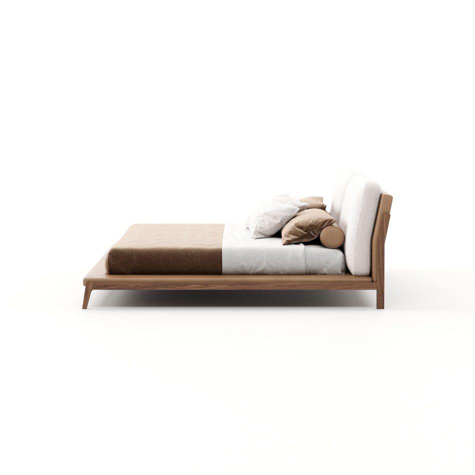Side profile of the Milos Bed, capturing the low, elongated silhouette of its walnut frame, the tan leather base, and the gently sloped bouclé headboard. The pared-back proportions and finish detail speak to the kind of bedroom furniture design built for long-term versatility across different decorative styles.