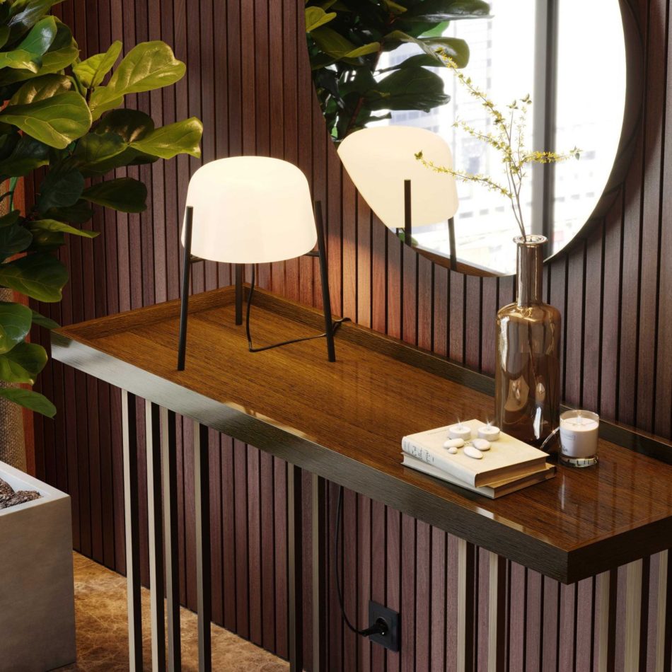 The Vector console sits against a wall of vertical slatted panels, styled with a contemporary lamp, a round mirror, and a vase of yellow branches. The surrounding greenery and warm lighting create a calm, curated atmosphere shaped by luxury home furniture, soft design details, and natural interior design inspiration.