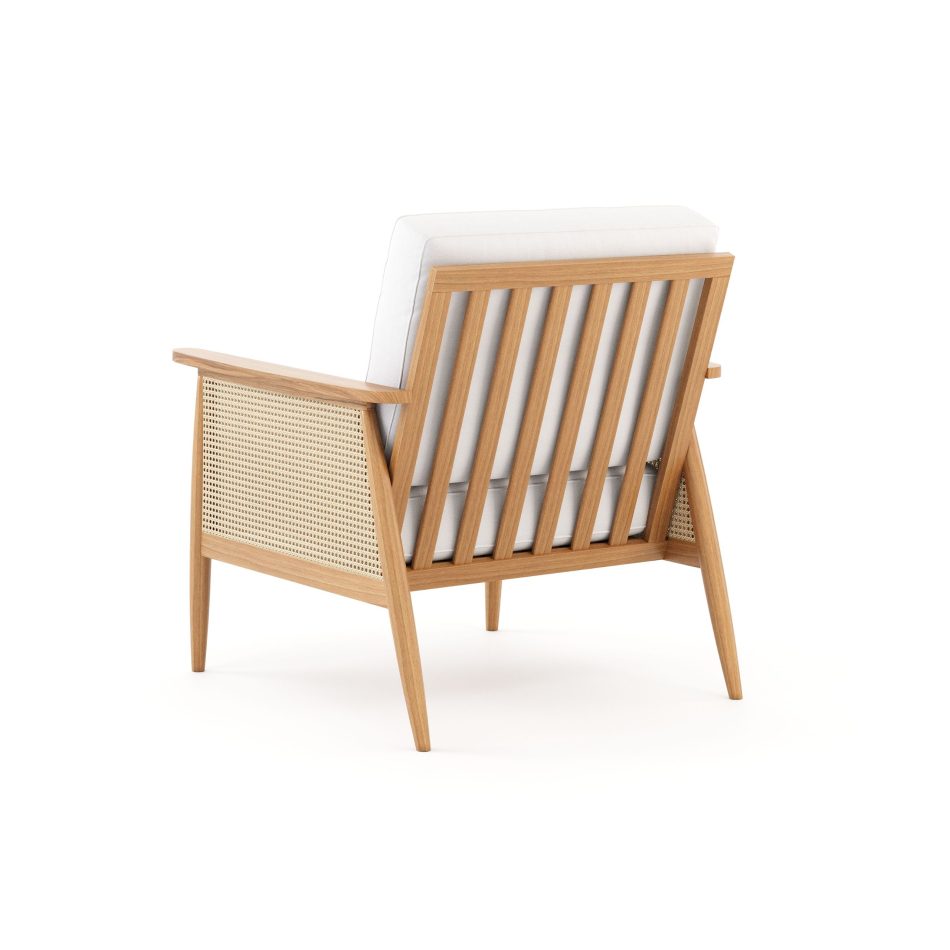 A back view of the Natur Armchair featuring a light wooden frame with vertical slats and woven cane panels, paired with soft neutral cushions. The combination of wood, cane, and fabric highlights the purity of natural materials, the crafted clarity of modern furniture, and the quiet balance central to minimalist design.