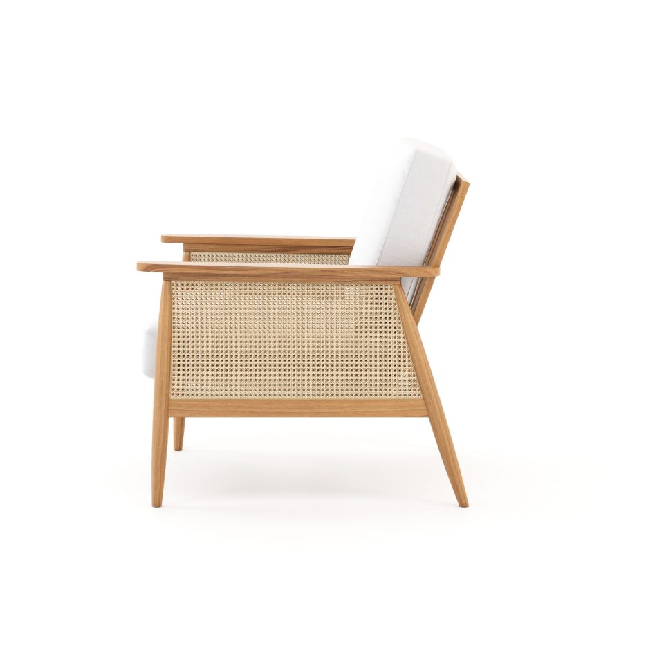 A side view of the Natur Armchair showing its angled wooden frame, woven cane side panel, and light upholstered cushions. The clean geometry and tactile textures express the harmony of contemporary furniture, the warmth of natural materials, and the thoughtful simplicity that defines nature‑inspired interior design.