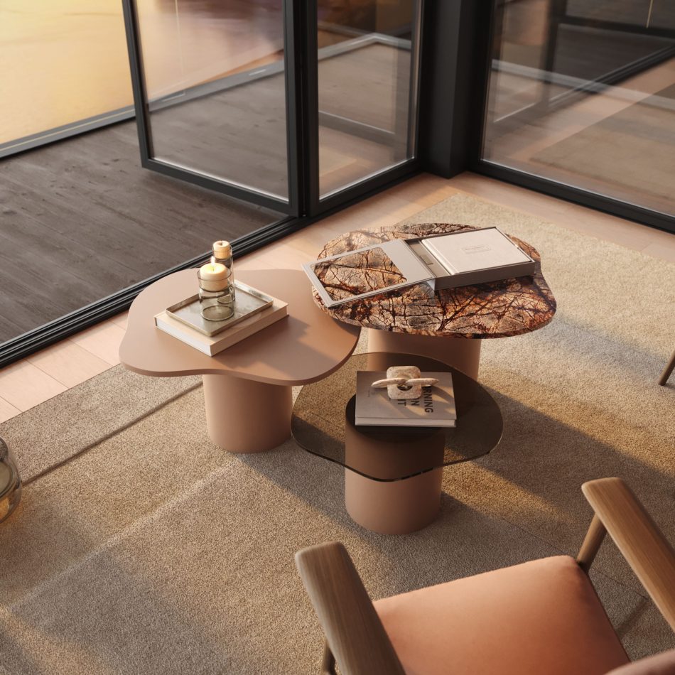 The Natur Side Tables appear as a trio of rounded, nature‑inspired forms with contrasting tops in matte, glossy, and textured finishes. Styled with candles, books, and decorative objects on a soft beige rug, the composition blends modern furniture, gentle design details, and serene interior design inspiration.