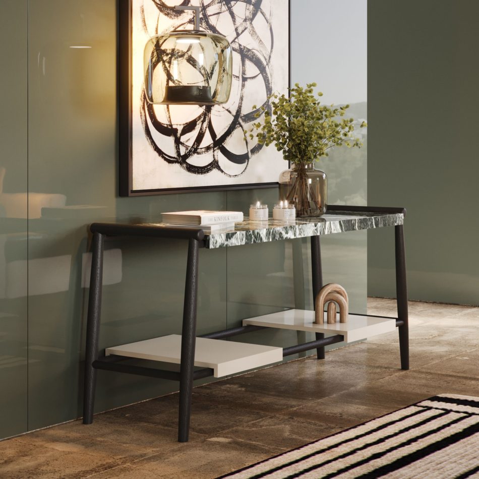 The Landform Console features a marble top resting on a dark wooden structure, styled with sculptural décor, books, and a glass vase that softens the composition. Set against a glossy green wall with a bold abstract artwork and a warm pendant light, the console brings quiet confidence to the room, mixing luxury home furniture, design details, and soft luxury interior design.