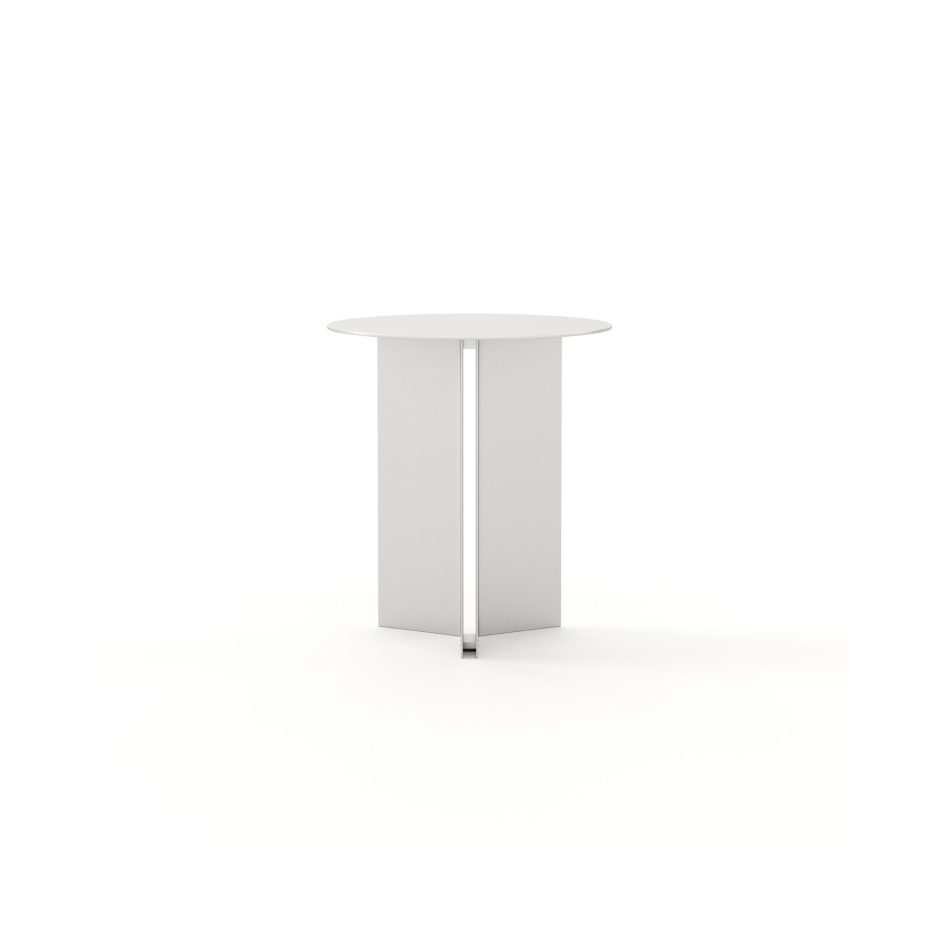 The Steel Side Table in stainless steel brushed is presented against a white backdrop, highlighting its round silhouette and intersecting base panels. The brushed finish brings a gentle texture to the surface, allowing the table to feel both light and grounded. This understated form complements modern furniture compositions, enhances the serenity of living room inspiration, and embodies the restraint and elegance associated with luxury home furniture.