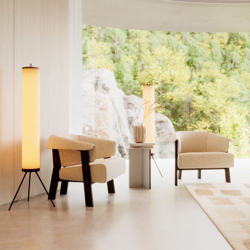 The Steel Side Table in stainless steel brushed stands between two neutral armchairs, illuminated by warm floor lamps that highlight its smooth, matte surface. The surrounding space opens to a lush outdoor view, creating a gentle dialogue between interior calm and nature. The composition reflects the balance of contemporary furniture, the comfort of home furniture, and the understated refinement of curated luxury furniture.