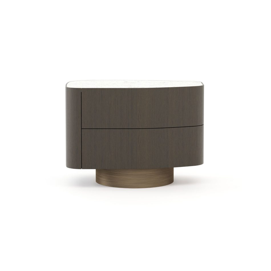 A rounded Stone Night Table II with a smooth marble top and walnut‑matt wooden body rests on a brushed bronze base, echoing the softened contours of river‑shaped stones. The piece blends luxury home furniture, organic design details, and serene interior design inspiration.