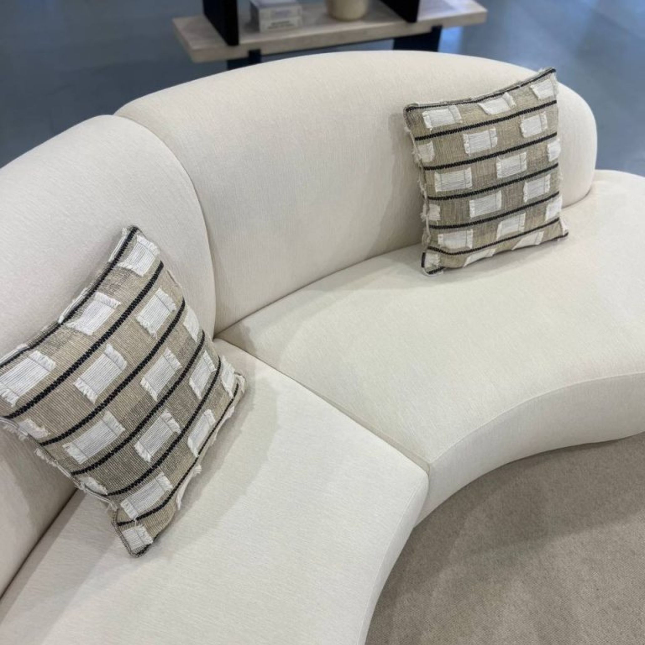 Cotton Sofa styled with textured neutral pillows in a Mediterranean-inspired living space that highlights the harmony between soft fabrics and wooden accents. This sofa brings a sense of flowing elegance and relaxed hospitality, essential pillars of the Mediterranean Aesthetic, while complementing sunlit interiors and natural materials.