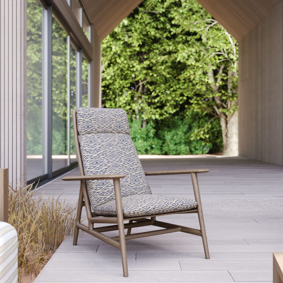 A detailed view of the Ripa Armchair in the Hamptons Villa’s outdoor space, upholstered in a beige and navy blue patterned fabric. Set against a tranquil natural backdrop, this elegant piece from Stylish Club’s outdoor selection embodies the timeless sophistication and relaxed Hamptons Style House exteriors.