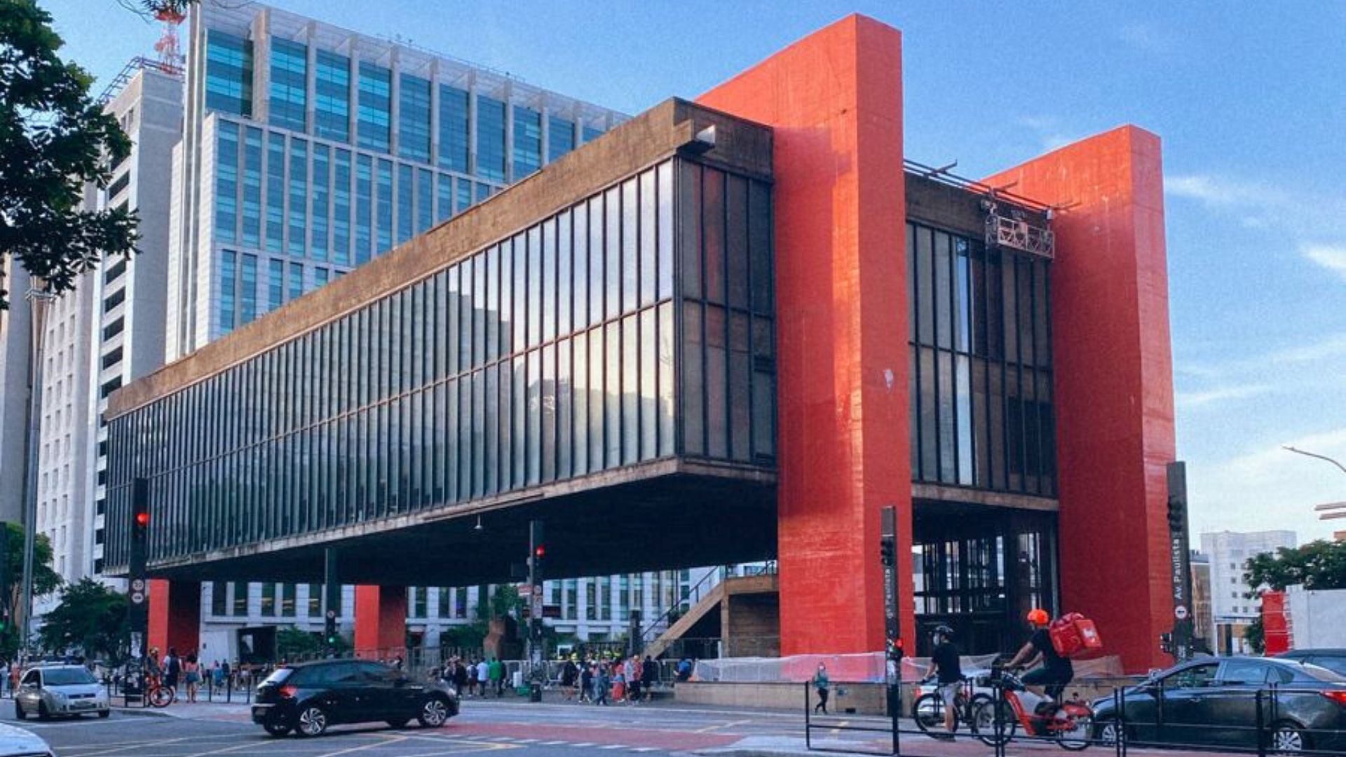View of the Museu de Arte de São Paulo (MASP), designed by Lina Bo Bardi. The concrete and glass structure is suspended by red beams, creating a monumental civic space beneath. This masterpiece of Lina Bo Bardi architecture exemplifies her drive to democratize access to art through innovative structural solutions.
