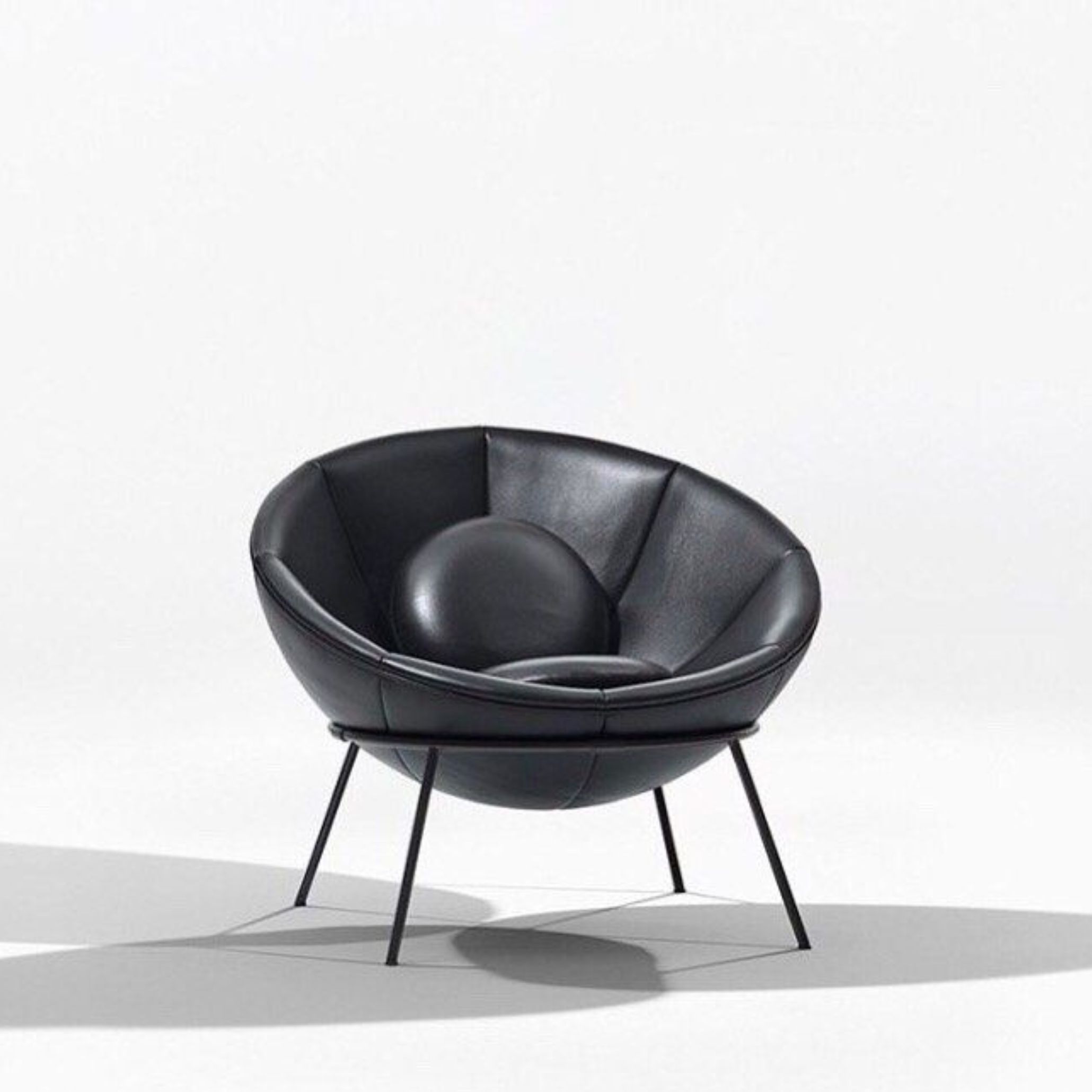 Studio image of the Bardi Bowl Chair in black leather, photographed against a white background. Designed by Lina Bo Bardi in 1951, this hemispherical seat symbolizes her blend of sculptural elegance and functional flexibility in furniture design.