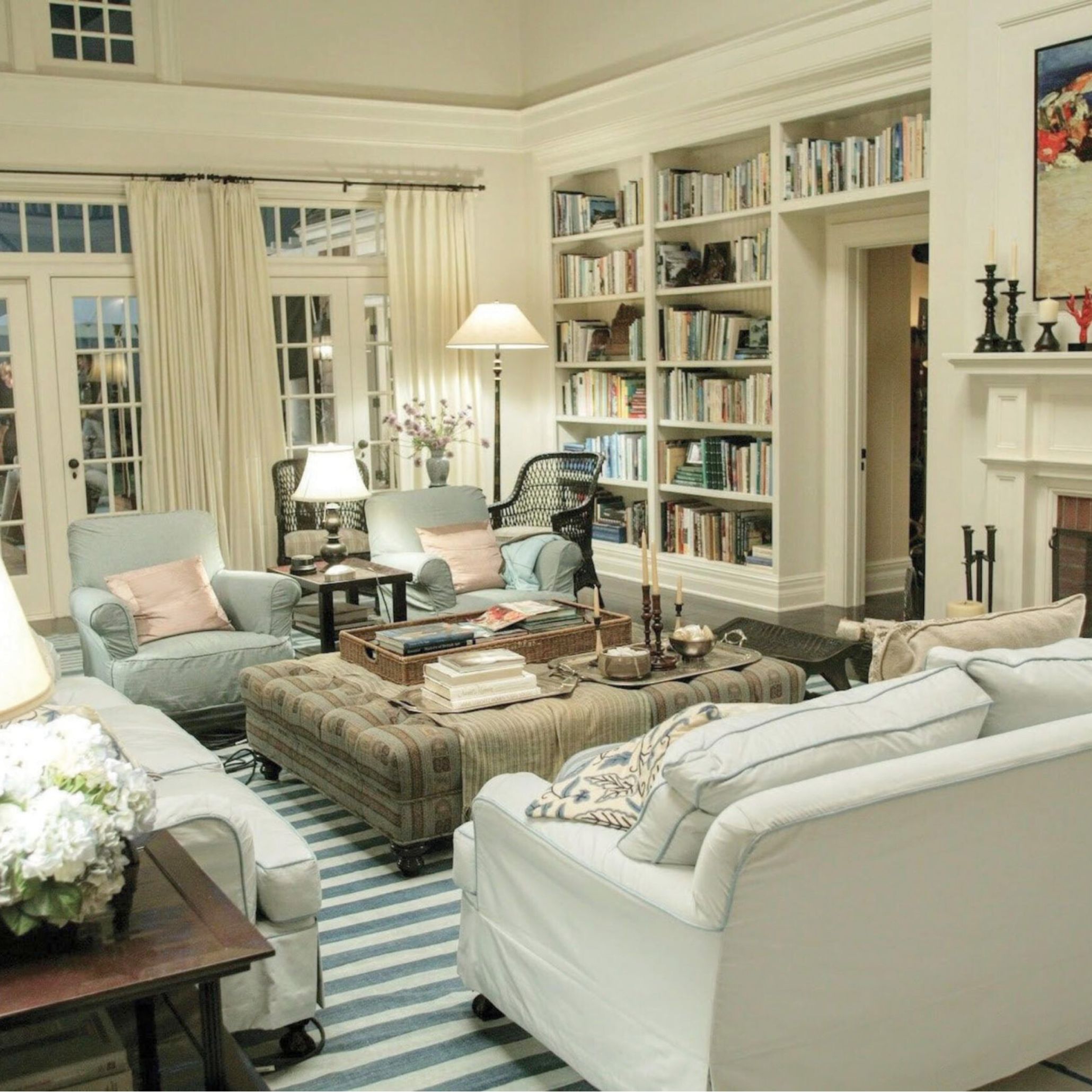 The iconic living room from the film “Something’s Gotta Give,” designed by Nancy Meyers, showcasing the blueprint of the Hamptons Style House. Layered lighting, classic built-in bookcases, plush slipcovered armchairs, and a palette of soft whites and muted pastels create a harmonious blend of comfort and sophistication. This room set the standard for modern Hamptons interior design, offering the perfect balance of warmth, luxury, and relaxed elegance.