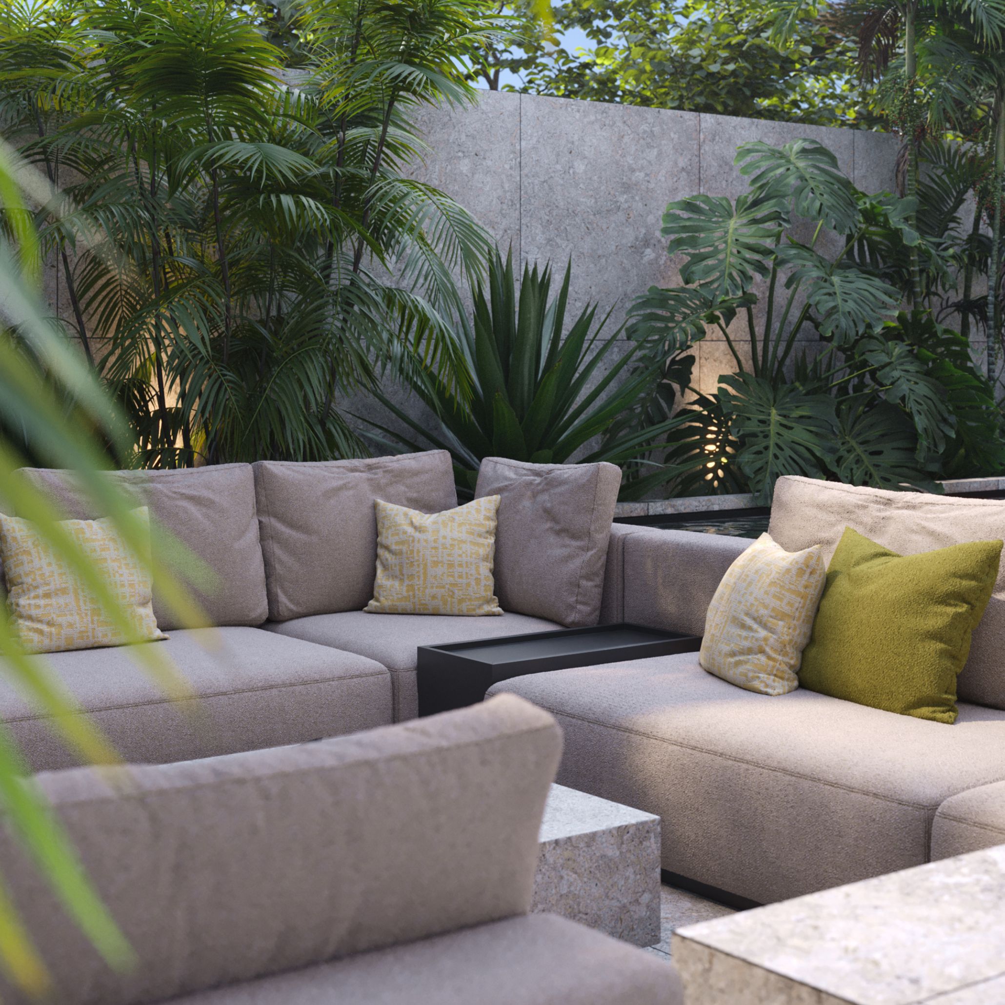 A cozy modular outdoor sofa in soft beige fabric, styled with layered cushions in mustard yellow and muted green tones. Surrounded by lush tropical greenery and stone finishes, this space showcases the 2025 trend of using refined textures, earth-inspired colours, and layered softness to create inviting, sensorial outdoor environments.