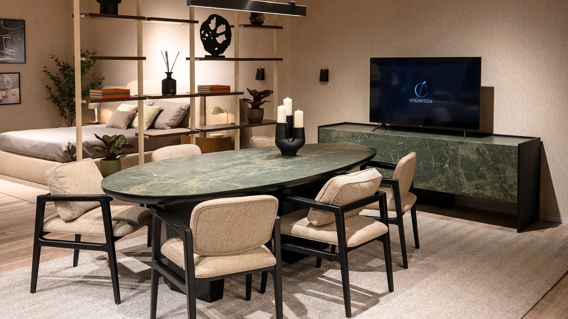 Stylish Club’s stand at Salone del Mobile showcases a green marble Stone Dining Table from the Stone collection paired with upholstered chairs. His Bookcase creates a refined partition to a serene bedroom, emphasizing the brand’s craftsmanship and elegant, thoughtful design. Her Sideboard, presented with the Stylish Club logo, reinforces the brand’s 2025 focus on transformative and enduring spaces.