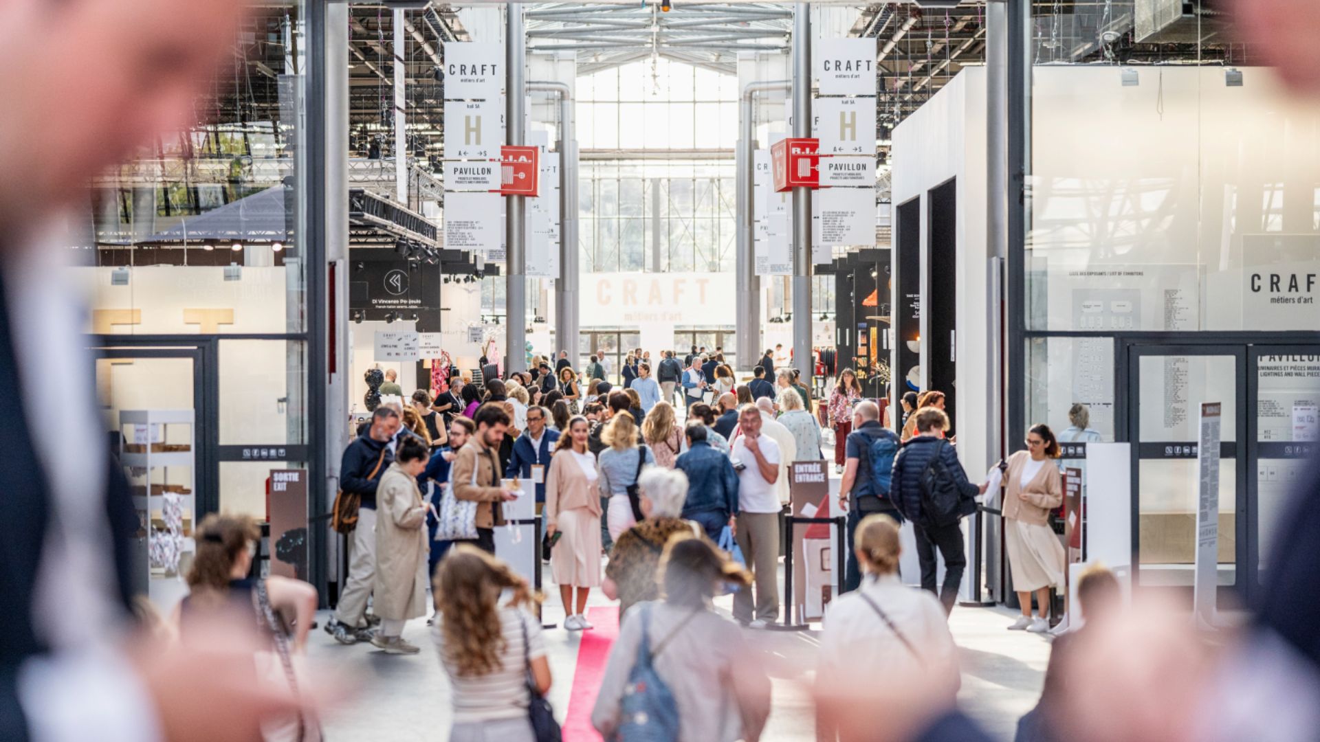 A busy crowd walks through the Maison & Objet fair, exploring contemporary furniture displays and new interior design trends.