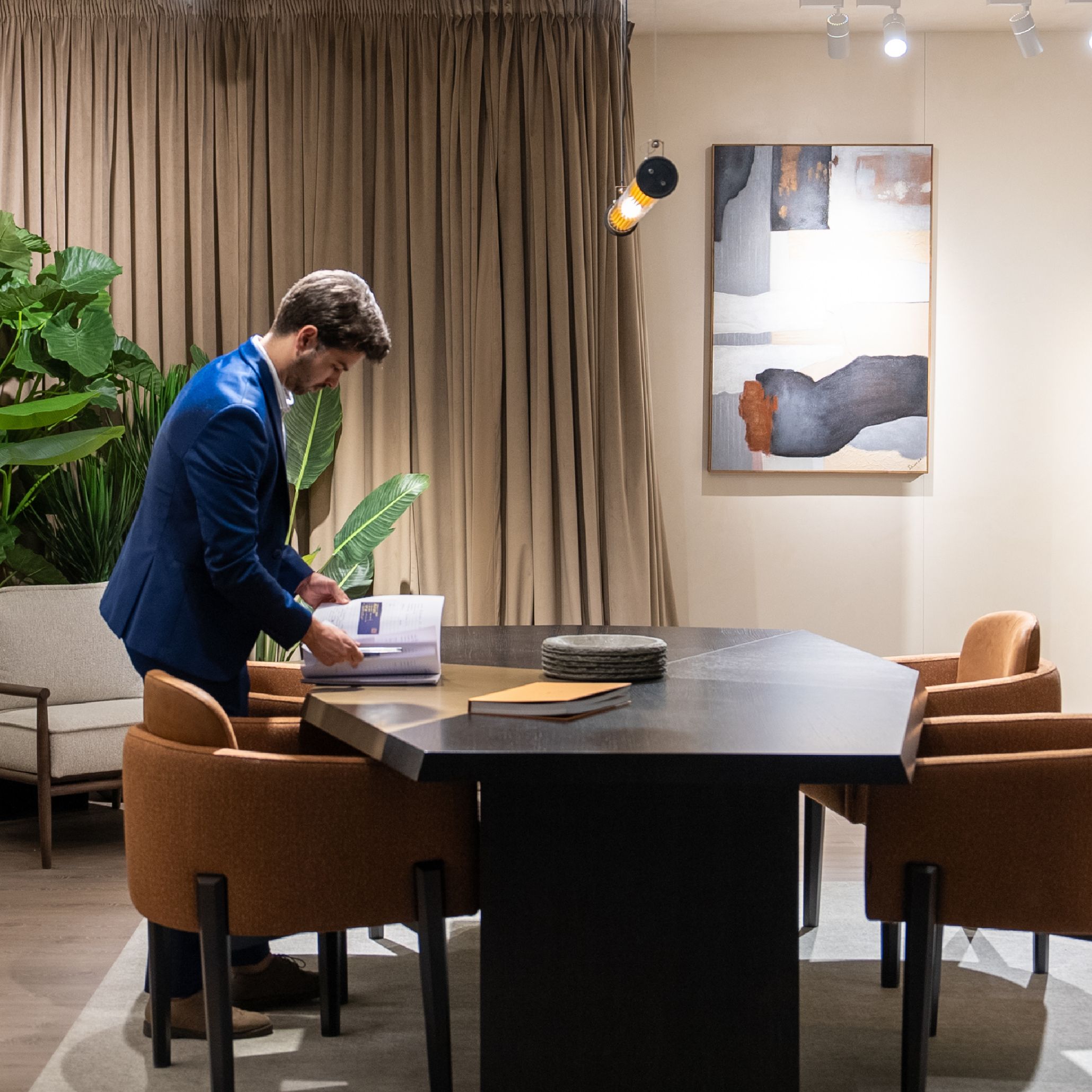 Stylish Club’s stand at Decorex 2025, with a team member organizing catalogues and preparing the display.