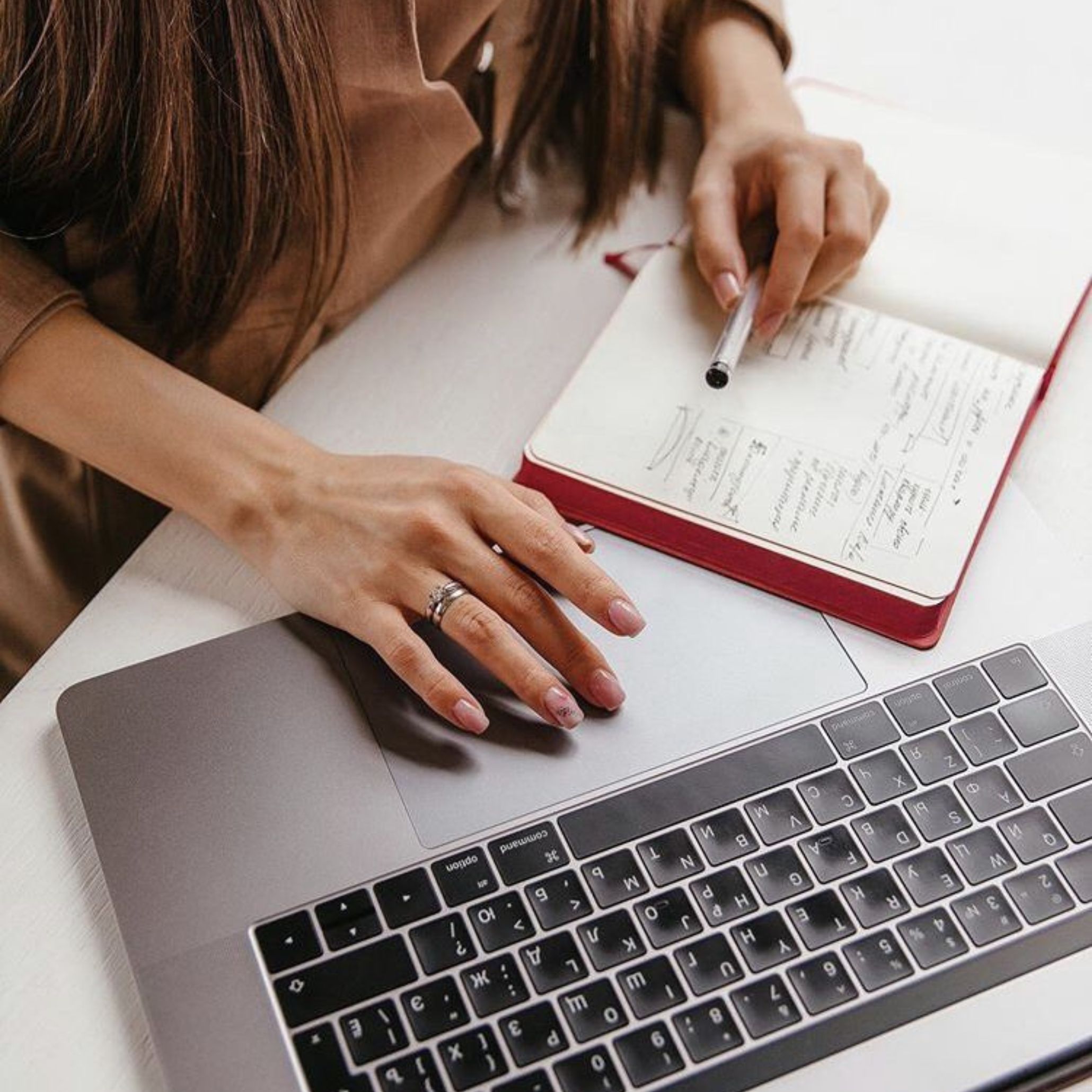 A woman planning her visit to a design fair, reviewing notes and organizing her schedule to explore interior design and furniture collections efficiently.
