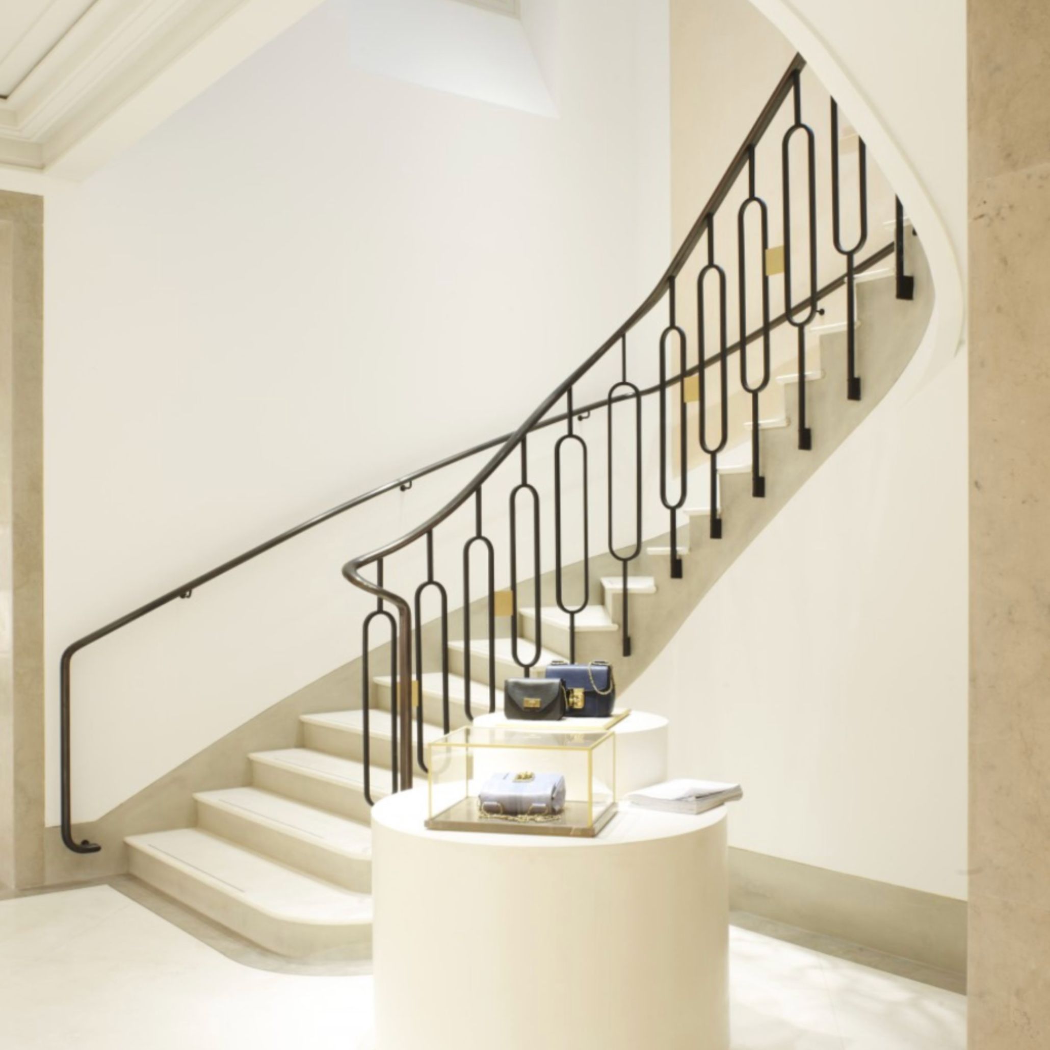 Interior view of Chloé’s Saint-Honoré flagship, featuring a sculptural staircase and refined material palette. Joseph Dirand’s architectural discipline guides circulation through clearly defined volumes, creating a seamless dialogue between fashion and space where elegance emerges from proportion, light, and restraint.