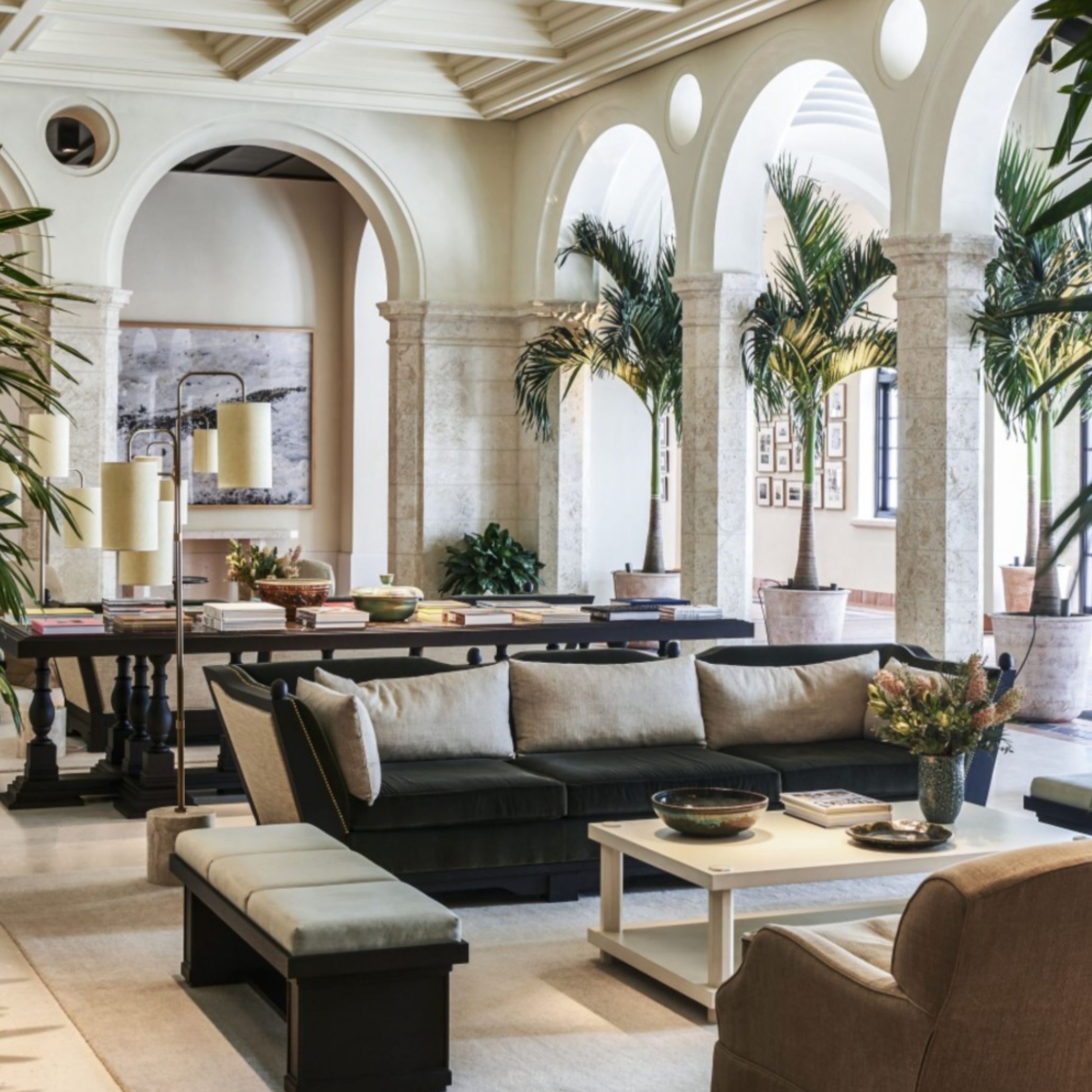 A serene interior from The Surf Club, featuring sculptural furniture, warm materials, and framed views toward the coast. The space reflects Joseph Dirand’s balance of openness and structure, where stone surfaces, controlled proportions, and measured light create a calm, enduring atmosphere connected to the surrounding landscape.