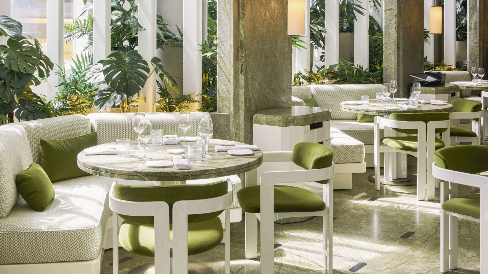 Interior of Le Jardinier in New York, featuring green marble tables, white seating, and lush plants. Joseph Dirand’s design creates a moment of pause through balance, repetition, and softened light - an atmosphere where silence, material stability, and spatial alignment evoke emotional presence.