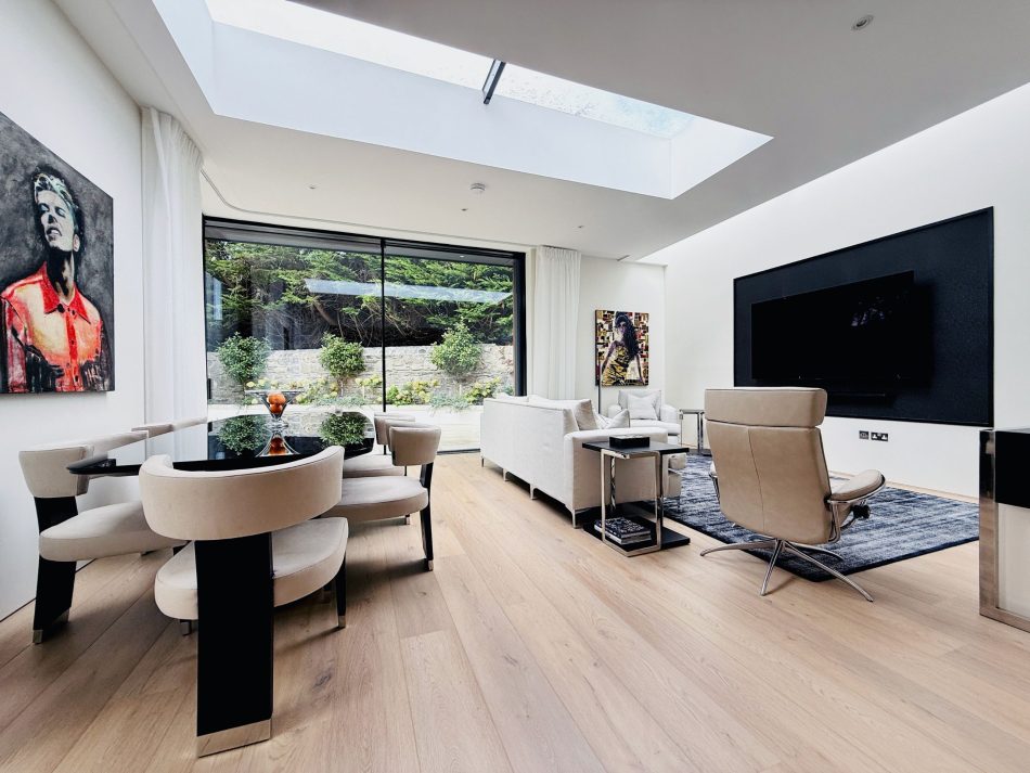 Open-plan living and dining area at Rathgar Villa, featuring the Her Dining Table and Her II Chairs beneath a skylight - an elegant space for gathering and connection.
