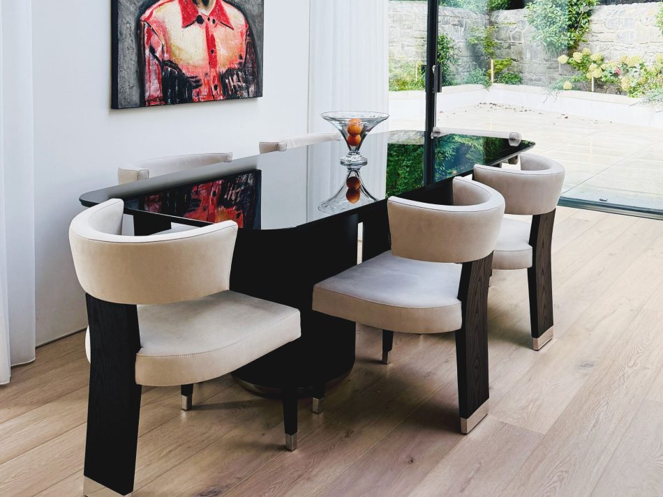 Elegant dining space at Rathgar Villa featuring the Her Dining Table and Her II Chairs, framed by natural light and expressive artwork, designed for shared moments and lasting impressions.