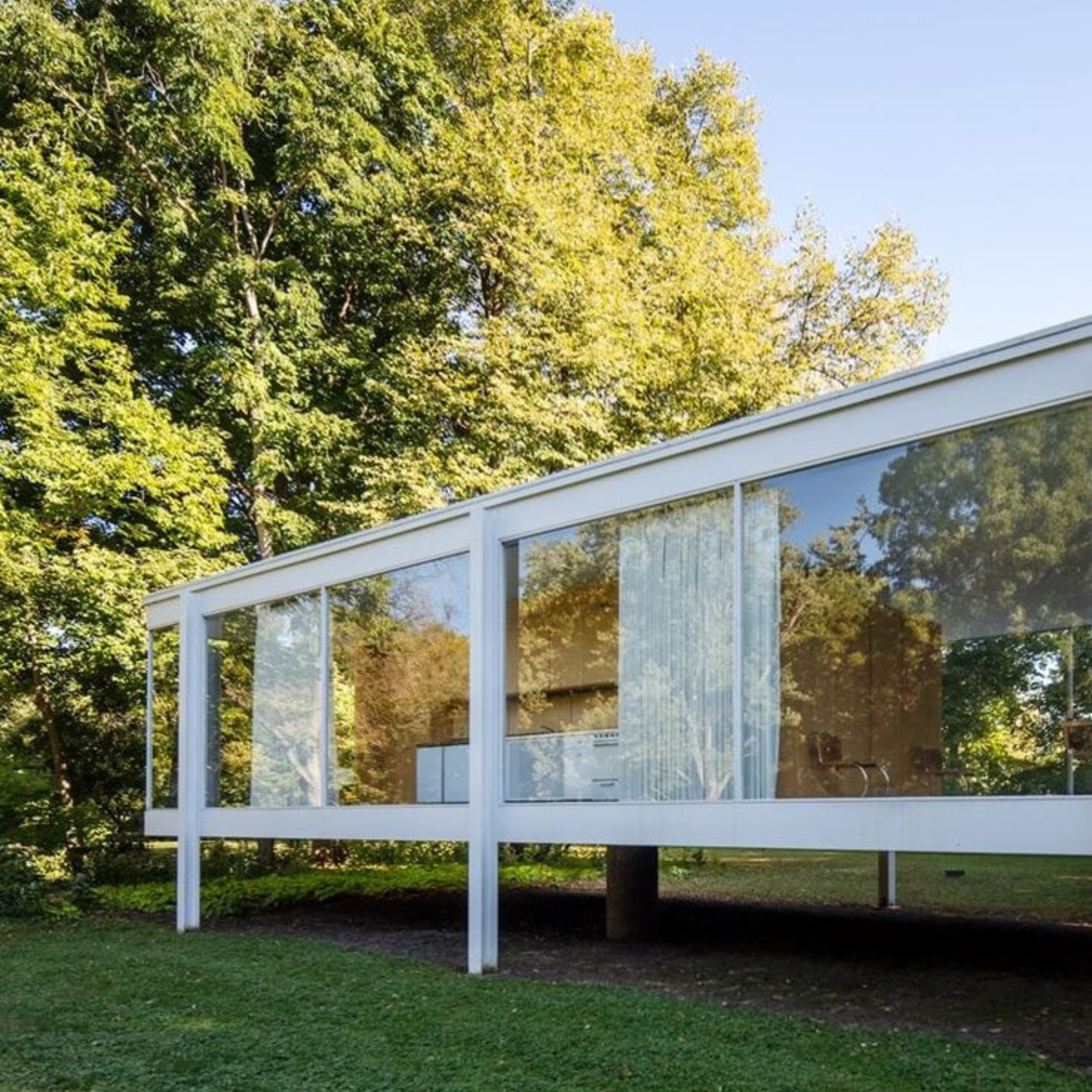 The Farnsworth House appears weightless among the trees, its floor‑to‑ceiling glass dissolving the boundary between interior and exterior. Inside, the open plan and central core suggest a new way of living defined by openness, proportion, and minimalist design. The visible furnishings echo Mies van der Rohe’s commitment to custom furniture and subtle design details, reinforcing the house’s role as an architectural manifesto where luxury furniture is expressed through restraint rather than excess.