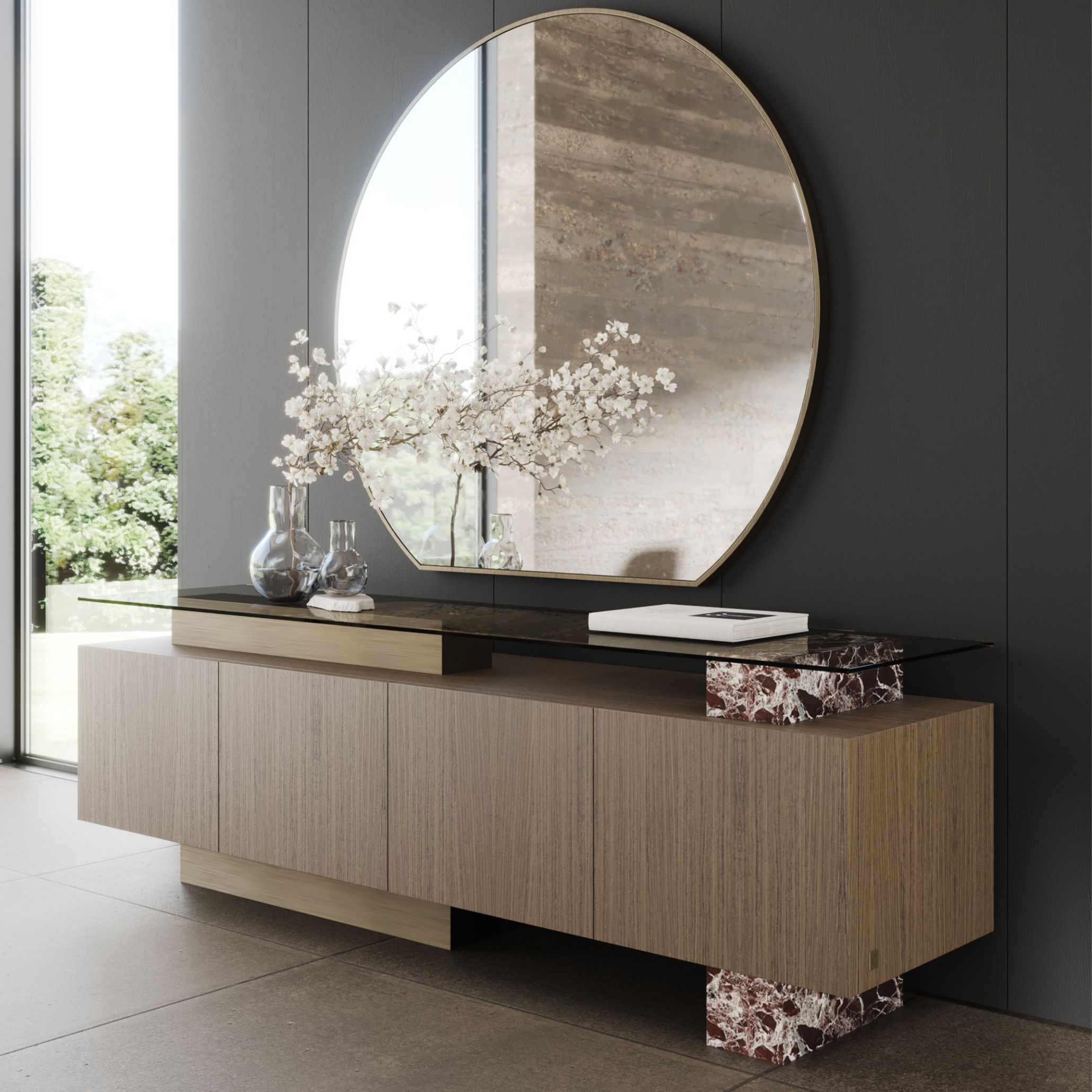 A modern interior vignette featuring the Toro Sideboard, combining warm wood cabinetry with a sleek glass top and sculptural marble bases. The arrangement showcases sideboard design within contemporary furniture design, with glass décor and soft floral accents adding refined design details. The scene offers modern furniture and interior design inspiration through its harmonious mix of textures, materials, and natural light.