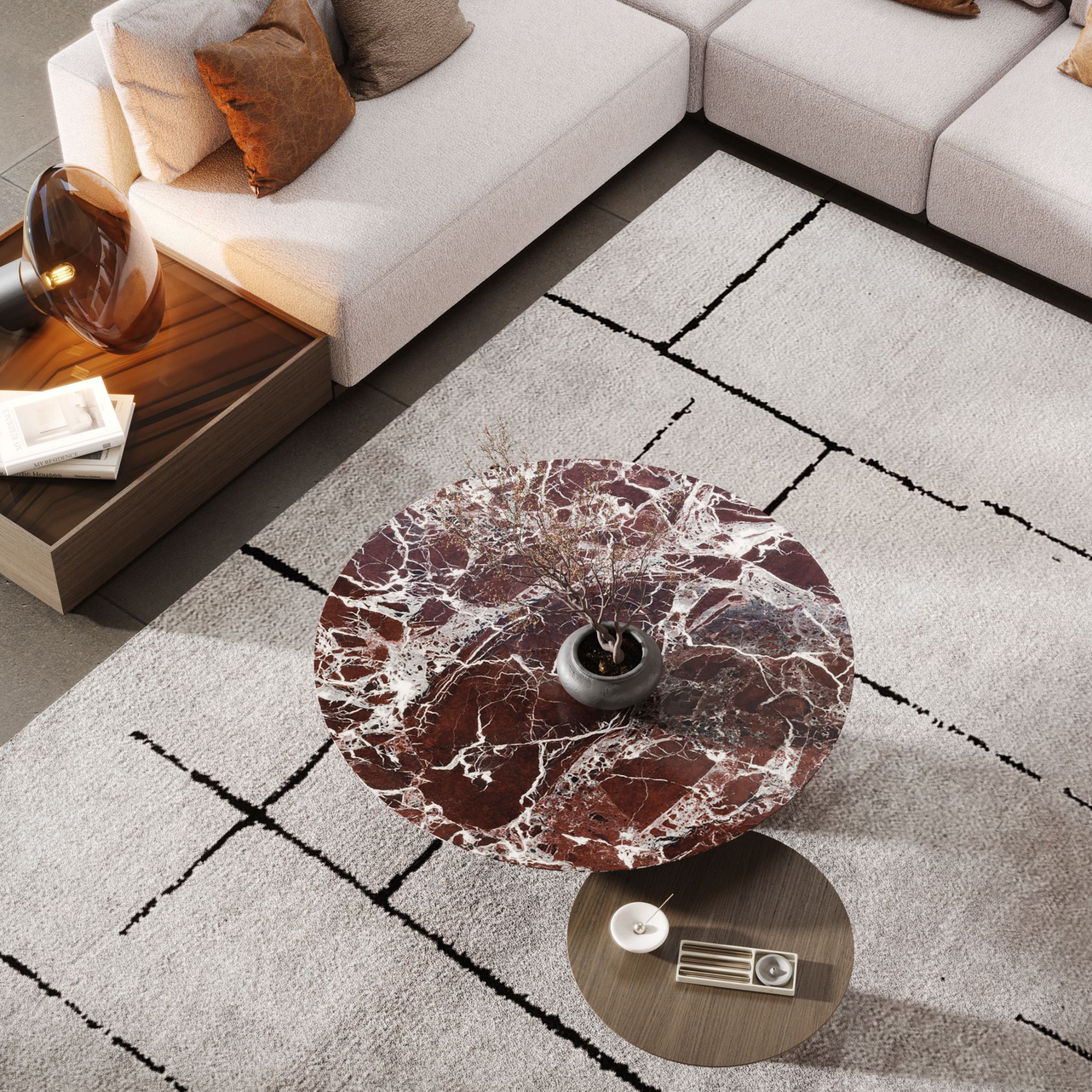 A warm living room design featuring a beige modular sofa paired with the Sahara luxury coffee table set, combining wood surfaces with a striking Rosso Levanto marble top. The arrangement highlights contemporary furniture design through its soft lines, layered textures, and thoughtful design details. Decorative accents and natural tones create an inviting atmosphere that blends elegance with comfort, offering inspiration for both living room and bedroom furniture styling.