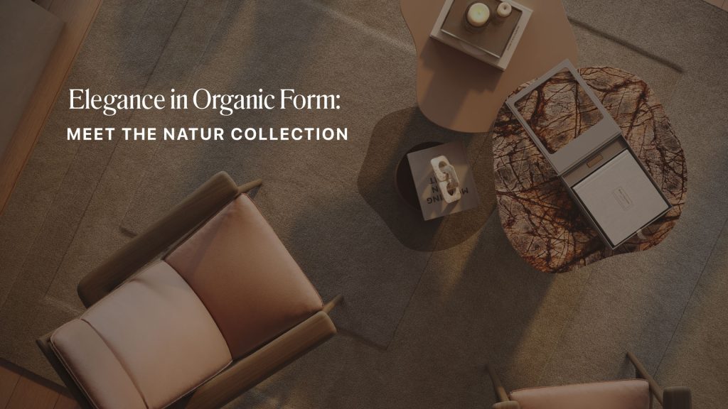 A warm, modern living space featuring wooden‑framed armchairs with soft blush cushions, arranged around a pair of sculptural Natur Coffee Tables in stone and lacquered finishes. Decorative candles, books, and textured accessories rest on the tables, enhancing the calm atmosphere. Soft lighting highlights the organic curves and natural materials that define the Natur Collection, reflecting the principles of organic furniture design, contemporary furniture aesthetics, and the quiet clarity of modern minimalist furniture.