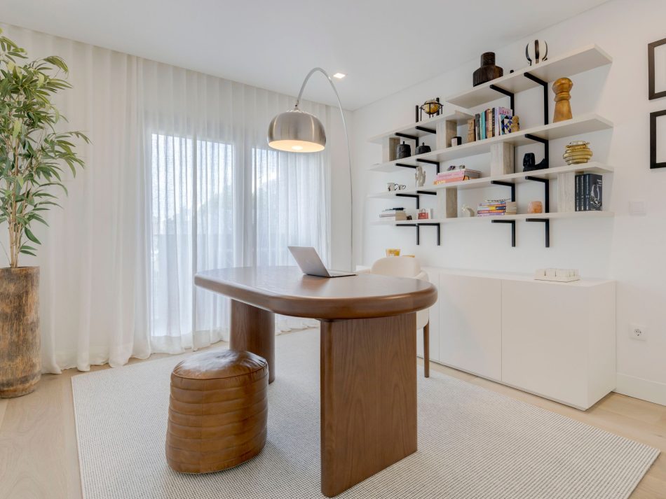 A serene home office where soft natural light enhances the warm textures of the bespoke Natur Dining Table, reimagined as a functional workspace. Its artisanal presence pairs effortlessly with the surrounding shelving, creating a balanced environment that supports focus and creativity. The composition blends office furniture with subtle touches of luxury home furniture, while maintaining the calm clarity associated with modern furniture design.