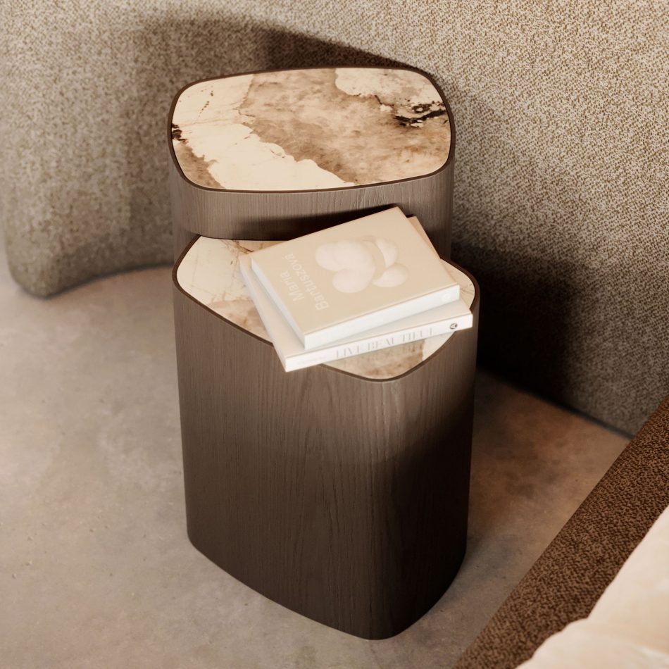 The Dolomites Side Table appears in a warm, contemporary living space, its dark brown wood base and marble top forming a soft, sculptural silhouette that echoes the quiet layering of mountain stone, blending naturally with the room’s neutral textures and embodying luxury furniture, the organic refinement of modern furniture, and the grounded calm of high end furniture.