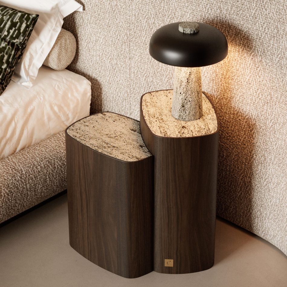 The Dolomites Side Table sits beside a softly layered bedscape, its dark brown wood silhouette and silver travertine marble top blending into a warm, textured bedroom where organic forms, gentle lighting, and natural materials create a quiet sense of refuge, aligning with luxury bedroom furniture, the crafted harmony of sophisticated bedroom furniture, and the serene balance found in bedroom architecture.