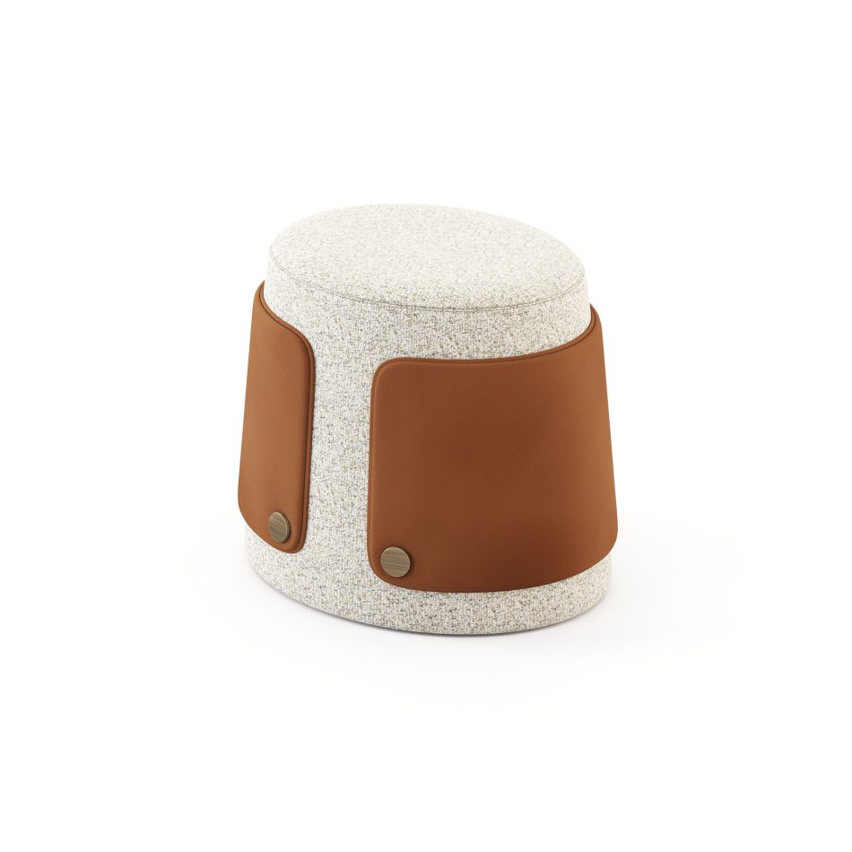 The Dolomites Stool is shown as a softly tapered cylindrical form wrapped in textured light upholstery, its rounded silhouette echoing the slow, natural shaping of stone over time. Two warm brown leather panels frame the lower body, each secured with a single brass button that highlights the crafted detailing associated with luxury home furniture. The gentle contrast between the tactile fabric and the structured leather brings a sculptural calm suited for living room furniture, while the thoughtful proportions reflect the refined character of high end furniture and the artisanal quality found in custom furniture.
