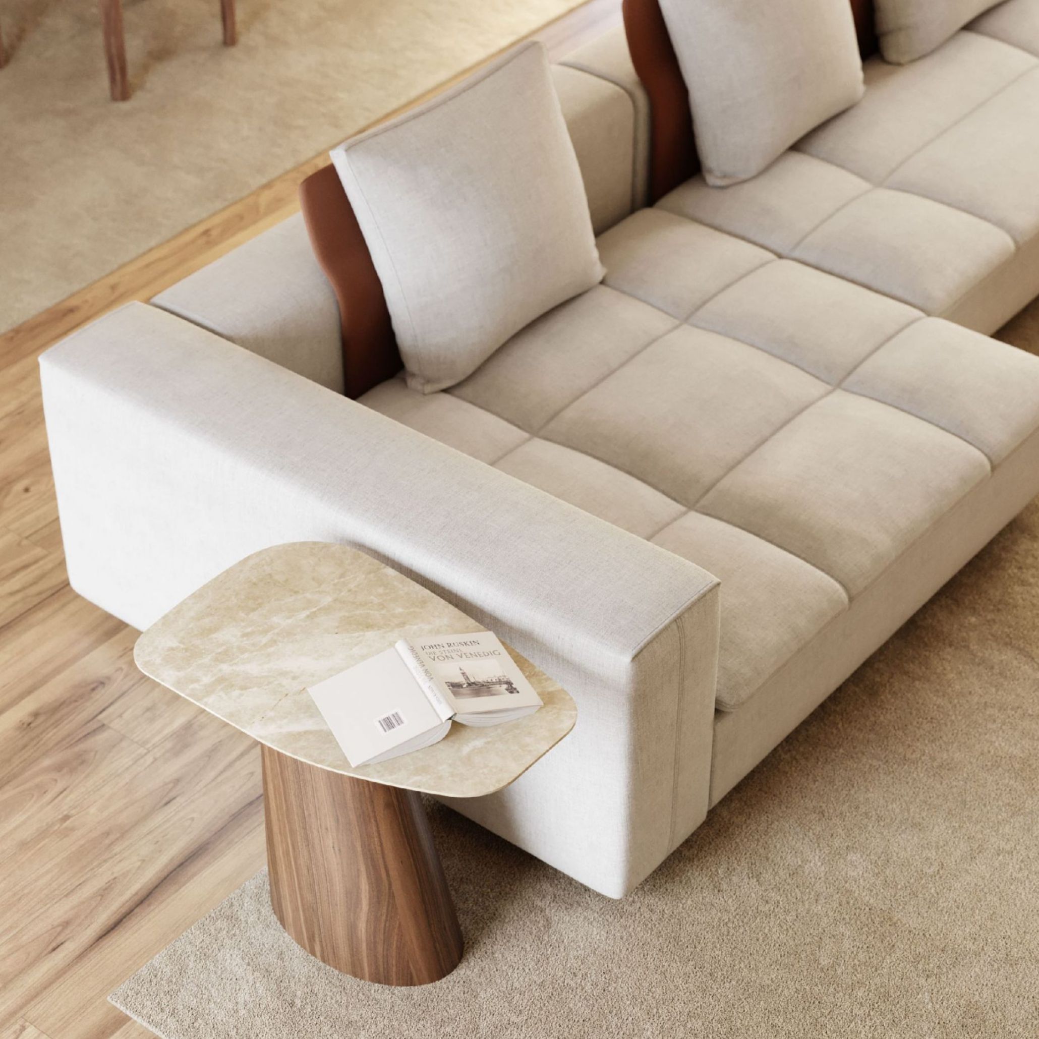 A contemporary living room with a neutral sectional sofa and a sculptural Stone Side Table that introduces the grounding presence of natural materials. The mix of soft textiles, marble surfaces, and warm tones reflects wellness‑focused interiors supported by elegant living room furniture, refined luxury home furniture, and the tactile authenticity of stone design elements.