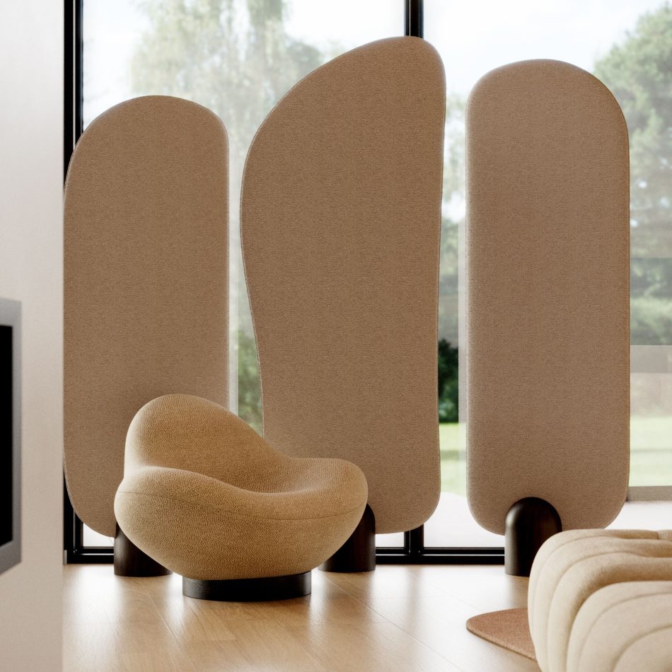 The Stone Screen stands behind the sculptural stone armchair with its three softly curved fabric panels rising in a gentle rhythm, each grounded by a rounded wooden base that brings a sense of stillness to the room. Natural light pours through the tall windows and moves across the textured surfaces, creating a calm atmosphere where the soft contours echo the slow shaping of nature and enrich the space with the refinement of luxury home furniture.