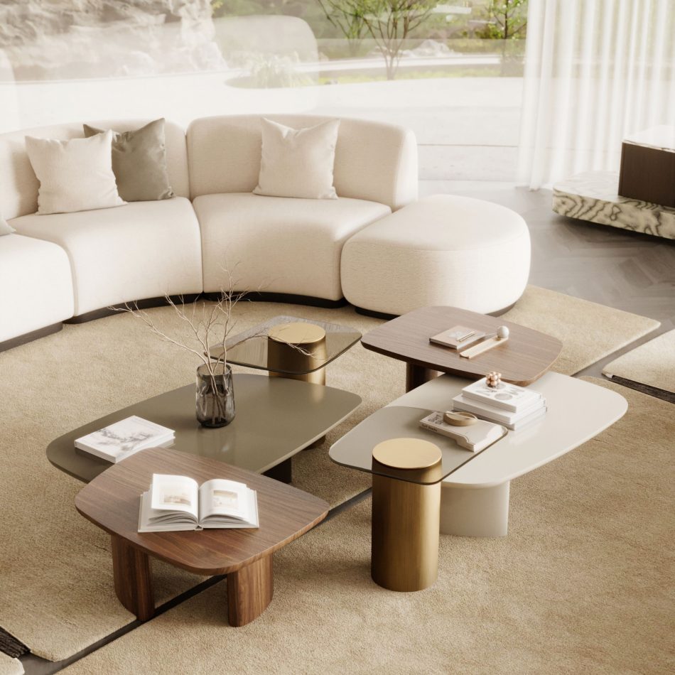 The Stone Sofa curves elegantly through the center of a warm, contemporary living room, its cream modular form layered with neutral pillows and surrounded by a curated mix of sculptural coffee tables in wood, lacquer, and metallic finishes, all resting on a soft beige rug and illuminated by floor‑to‑ceiling windows overlooking a peaceful garden, creating a harmonious space shaped by thoughtful living room architecture, subtle touches of modern furniture, curated furniture luxury design, and an inviting sense of living room inspiration.