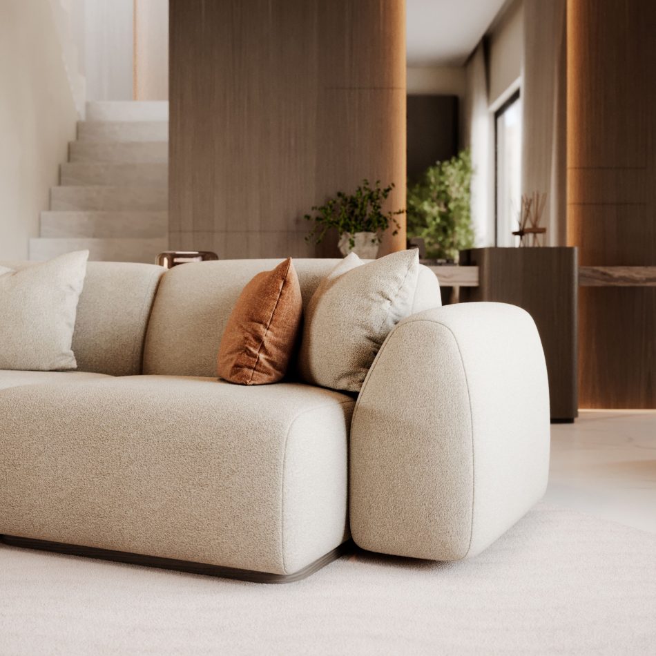 The Stone Sofa is shown in a soft beige upholstery with rounded edges and a low, sculptural profile, complemented by two matching cushions and a warm rust‑toned pillow, all set within a modern interior shaped by clean lines, natural materials, and subtle touches of contemporary furniture, gentle layers of living room inspiration, refined accents of luxury home furniture, and the inviting warmth associated with thoughtful design details.