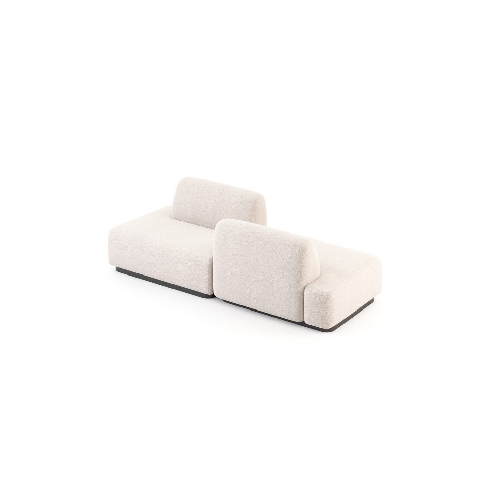 The Stone Sofa is arranged in a configuration with two connected modules upholstered in soft, light fabric and supported by a low dark base. The cushions and gentle curves echo the quiet shaping of river stones, creating a calm and grounded presence that reflects the natural balance of luxury furniture and the sculptural comfort of contemporary living room design.