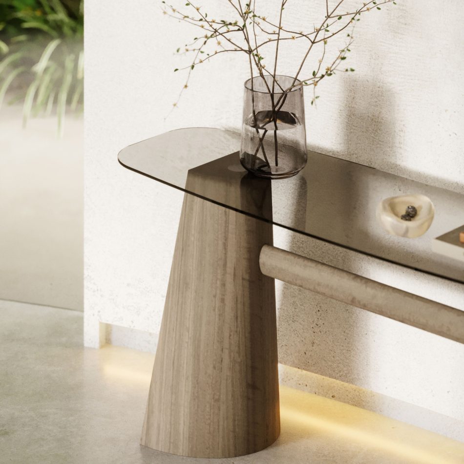 The Toro Console in wood and glass is shown in a minimalist interior where soft lighting, textured walls, and delicate décor create an atmosphere of calm refinement that mirrors the console’s intentional geometry and crafted restraint, resonating with luxury home furniture, the sculptural clarity of console table design, and the timeless balance of modern furniture.