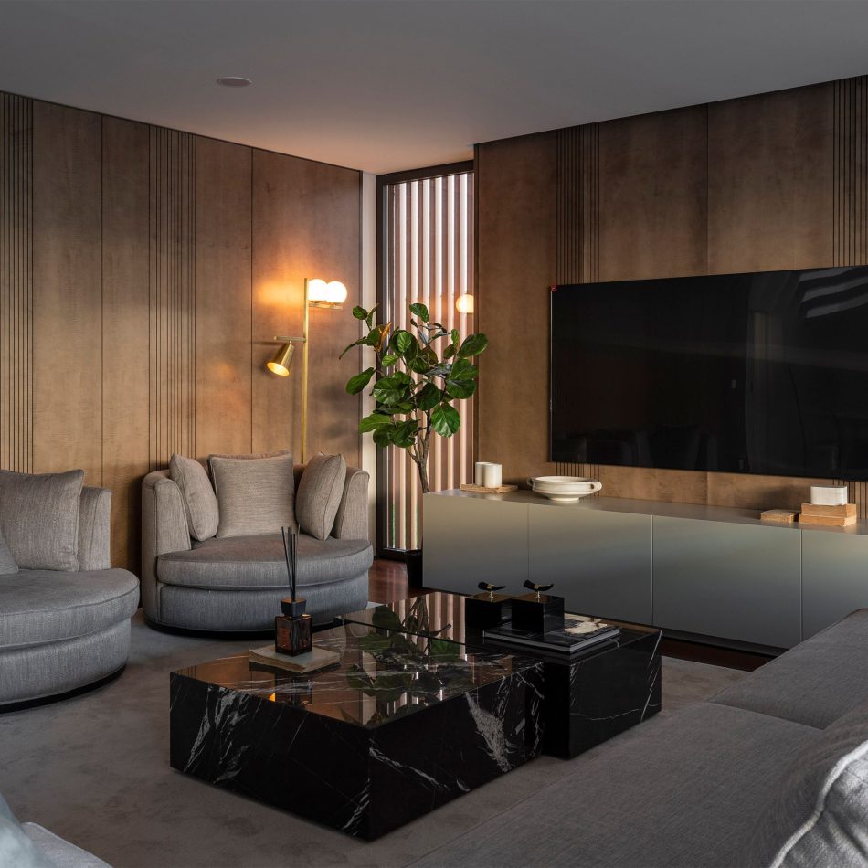 A refined living room where the Fortune Sofa anchors the space with its generous, tailored form, complemented by the presence of the Empire Armchair. Vertical wood paneling, a marble coffee table, and soft neutral tones create a Nordic‑inspired atmosphere shaped by luxury living room furniture, warm interior design inspiration, and the crafted balance of contemporary furniture.