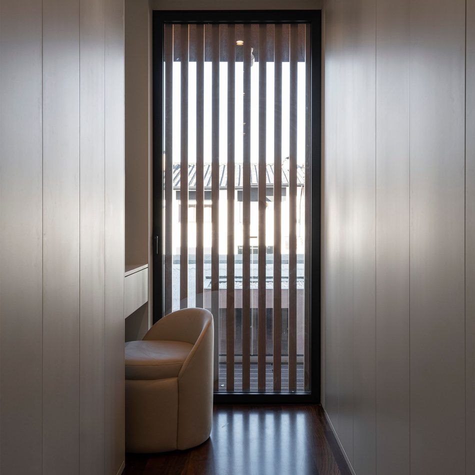 A narrow, light‑filled corner where the Elis Stool introduces a delicate sculptural presence beneath the soft rhythm of vertical slats. The warm flooring and gentle natural light enhance the sense of intimacy, expressing bespoke furniture, serene interior design inspiration, and the quiet refinement that defines contemporary living spaces.