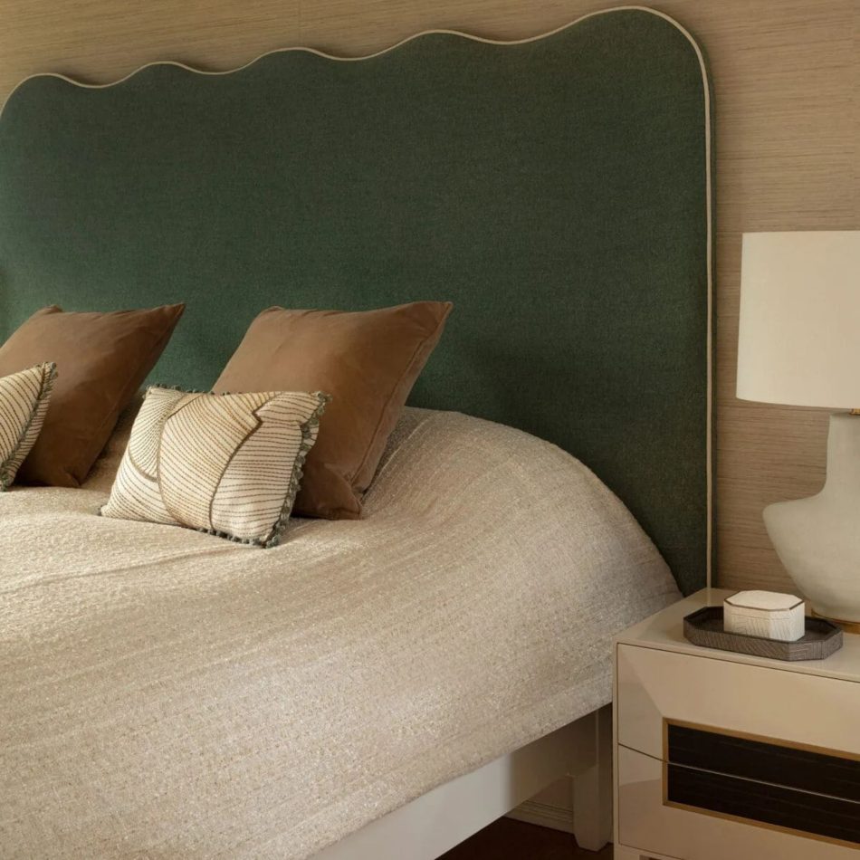 A refined master‑suite composition featuring a sculptural green headboard, layered pillows, and a textured blanket, paired with the Heritage Night Table adorned with a sculptural lamp and curated accents. The warm palette and crafted details embody high end bedroom furniture, elegant bedroom furniture, timeless design details, and the serene sophistication of luxury master bedroom furniture within a contemporary setting.