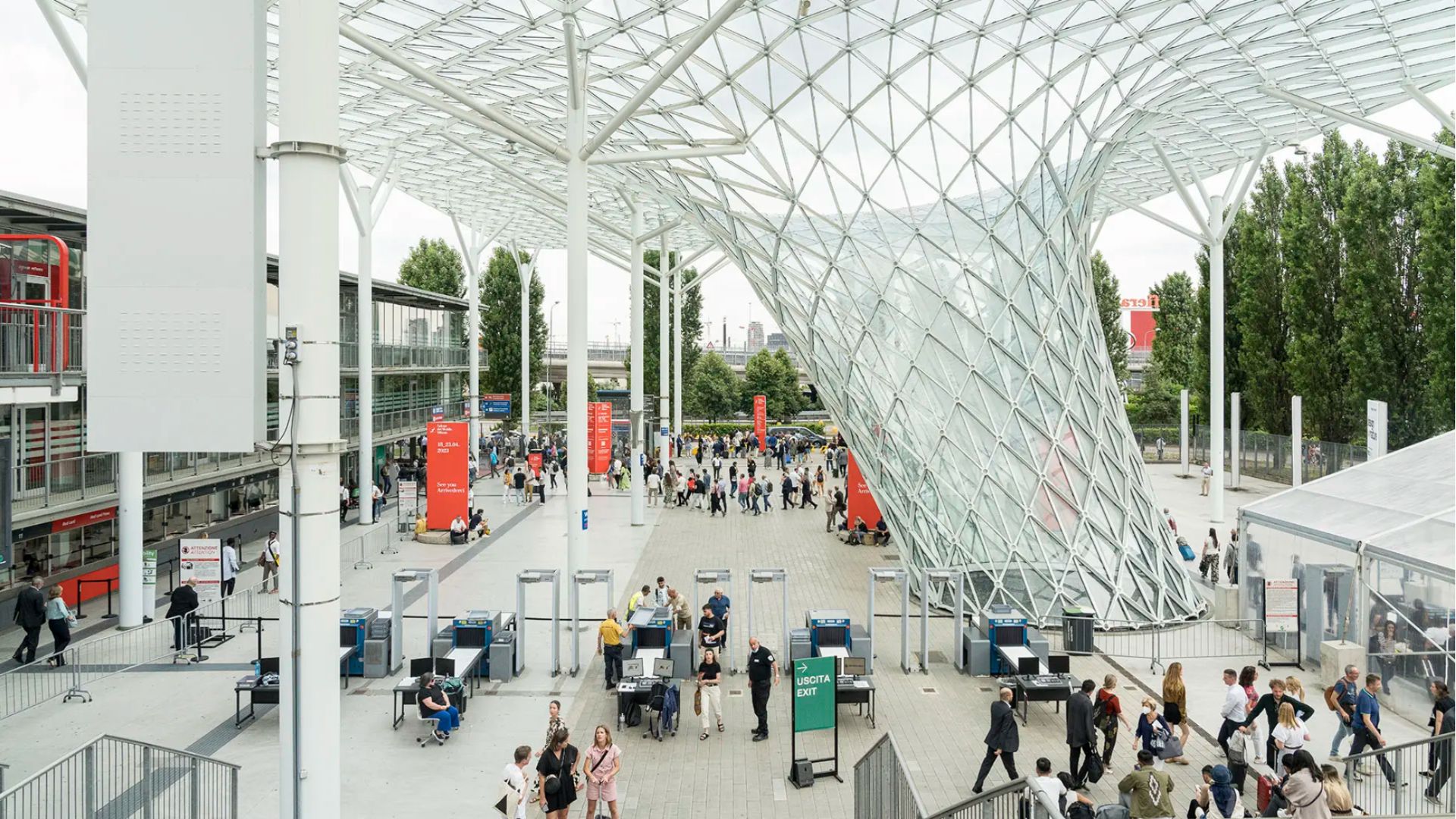 Crowds move beneath the sweeping glass‑and‑steel canopy at the Salone del Mobile 2025 entrance, where the scale of the architecture sets the rhythm for the week ahead. The open structure becomes a threshold into Milan’s creative energy, welcoming visitors exploring modern furniture innovations, discovering new directions in interior design inspiration, and engaging with the evolving landscape of luxury furniture during Milan Design Week.