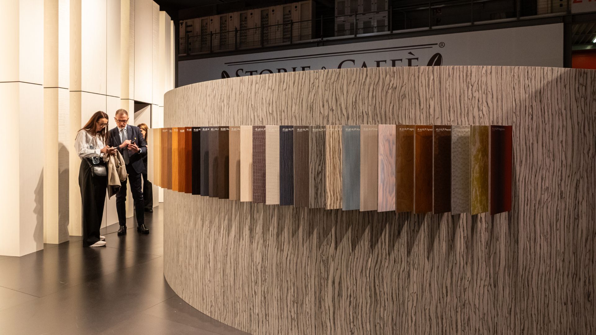 Visitors examine a display of material samples inside a Milan Design Week installation, where texture and surface take on a central role in shaping future interiors. The selection of finishes reflects a shift toward intentional, sustainable choices in luxury furniture, offering a preview of emerging interior design inspiration and highlighting how craftsmanship continues to influence modern furniture trends for 2026.
