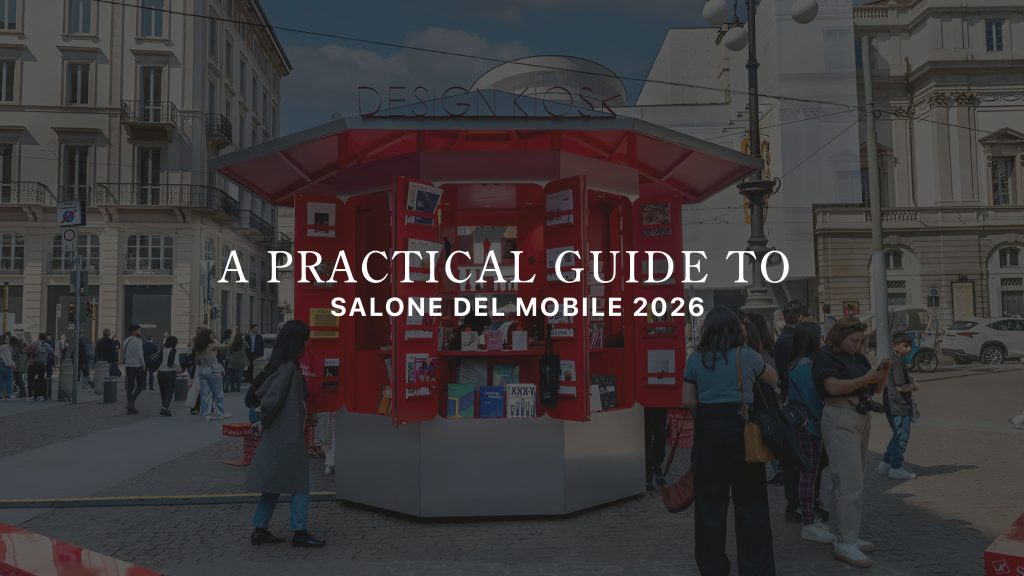 People gather around a bright red Design Kiosk on a busy Milan street, where conversations unfold as visitors browse books and design materials. The scene captures an informal client‑style interaction in the city’s design atmosphere, shaped by interior design inspiration, surrounded by hints of modern furniture culture, and connected to the broader world of contemporary furniture showcased during Salone del Mobile.